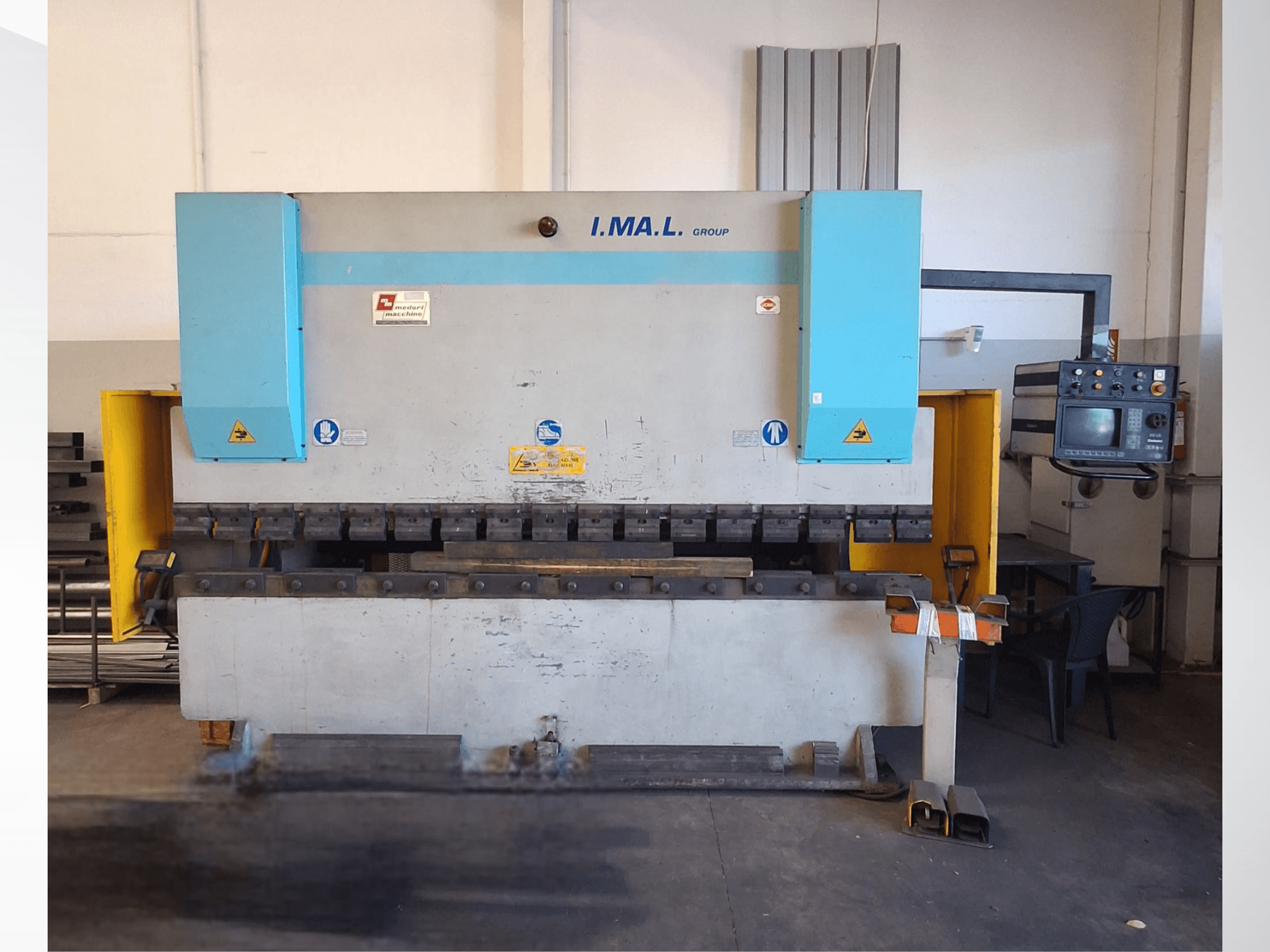 Framifrånvy av en IMAL E3A 100/33 kantpress, med kontrollpanel, bockverktyg och säkerhetsskyltar.