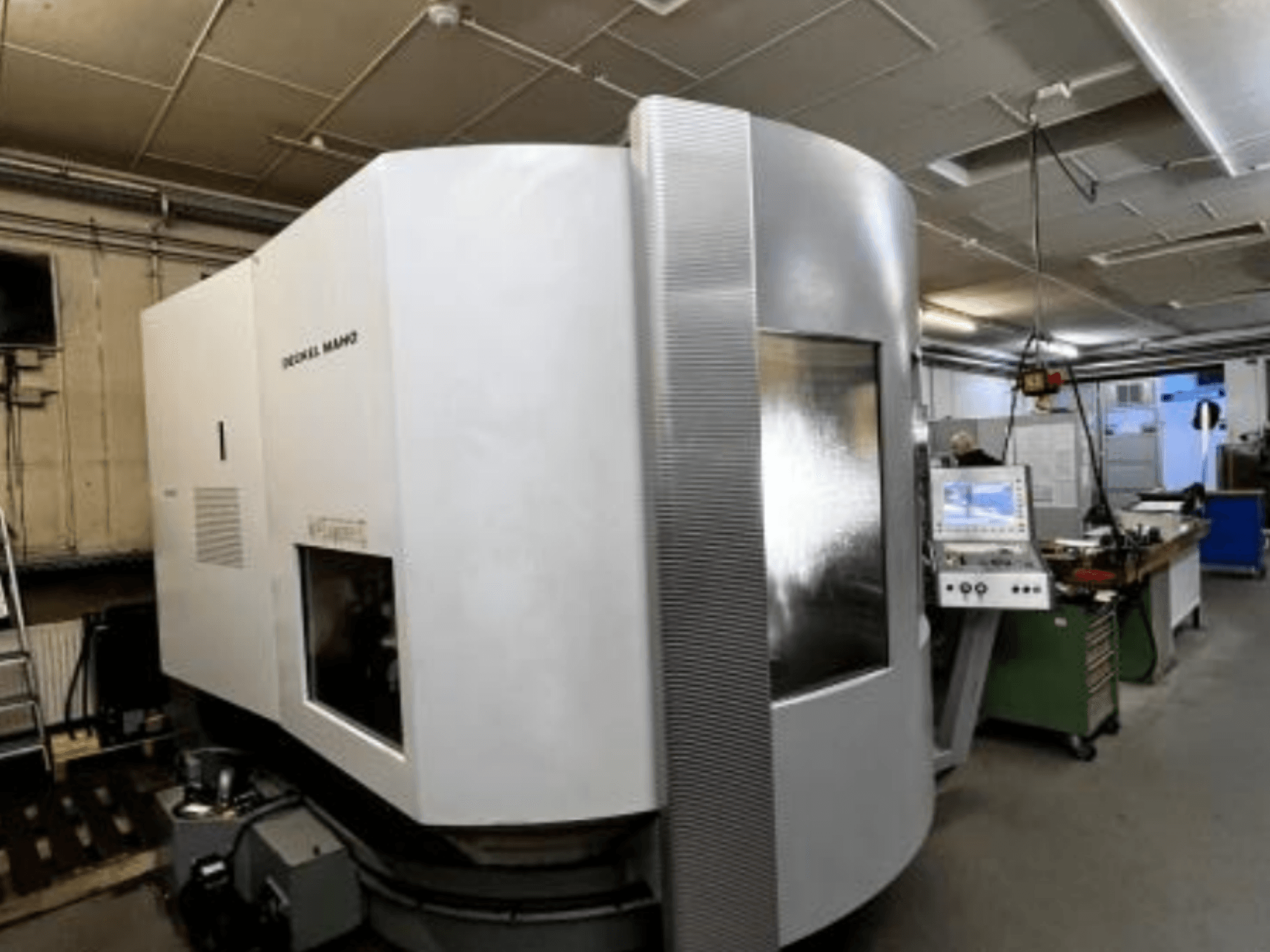 SODICK MAKO CNC-maskin i en verkstad, sidovy, med kontrollpanel och arbetsområde synliga i bakgrunden.