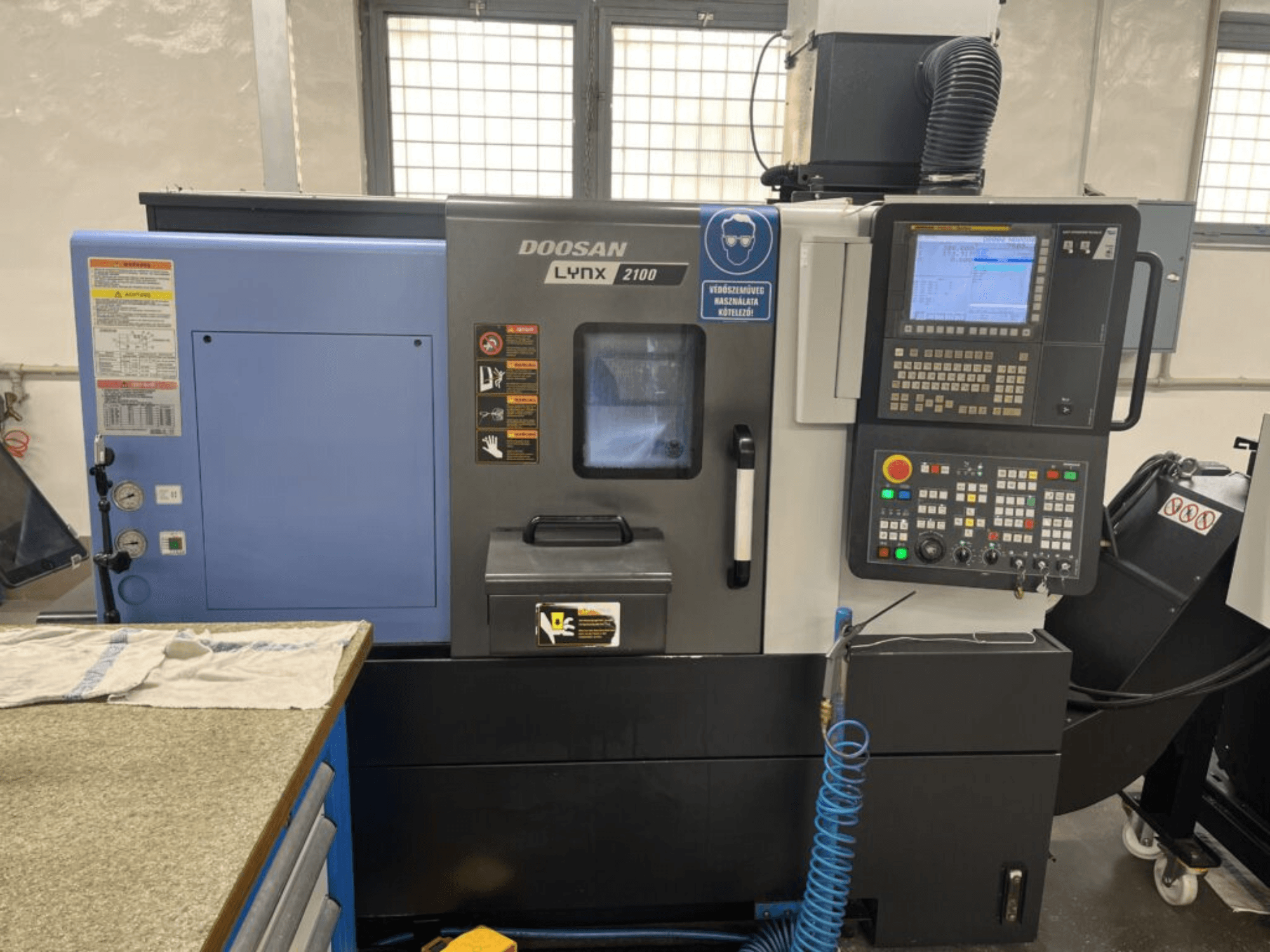 DOOSAN Lynx 2100A horisontell svarv, frontvy som visar kontrollpanelen, operatörsgränssnittet och maskinens funktioner.