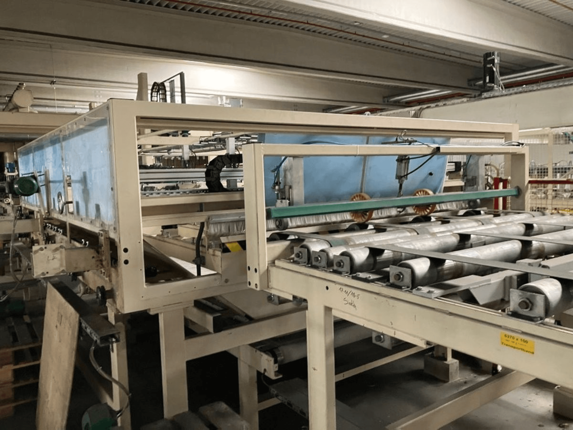 WEMHÖNER KT-F-1E lamineringspress, sidovy, med valsar och reglage för materialbearbetning i fabriksmiljö.