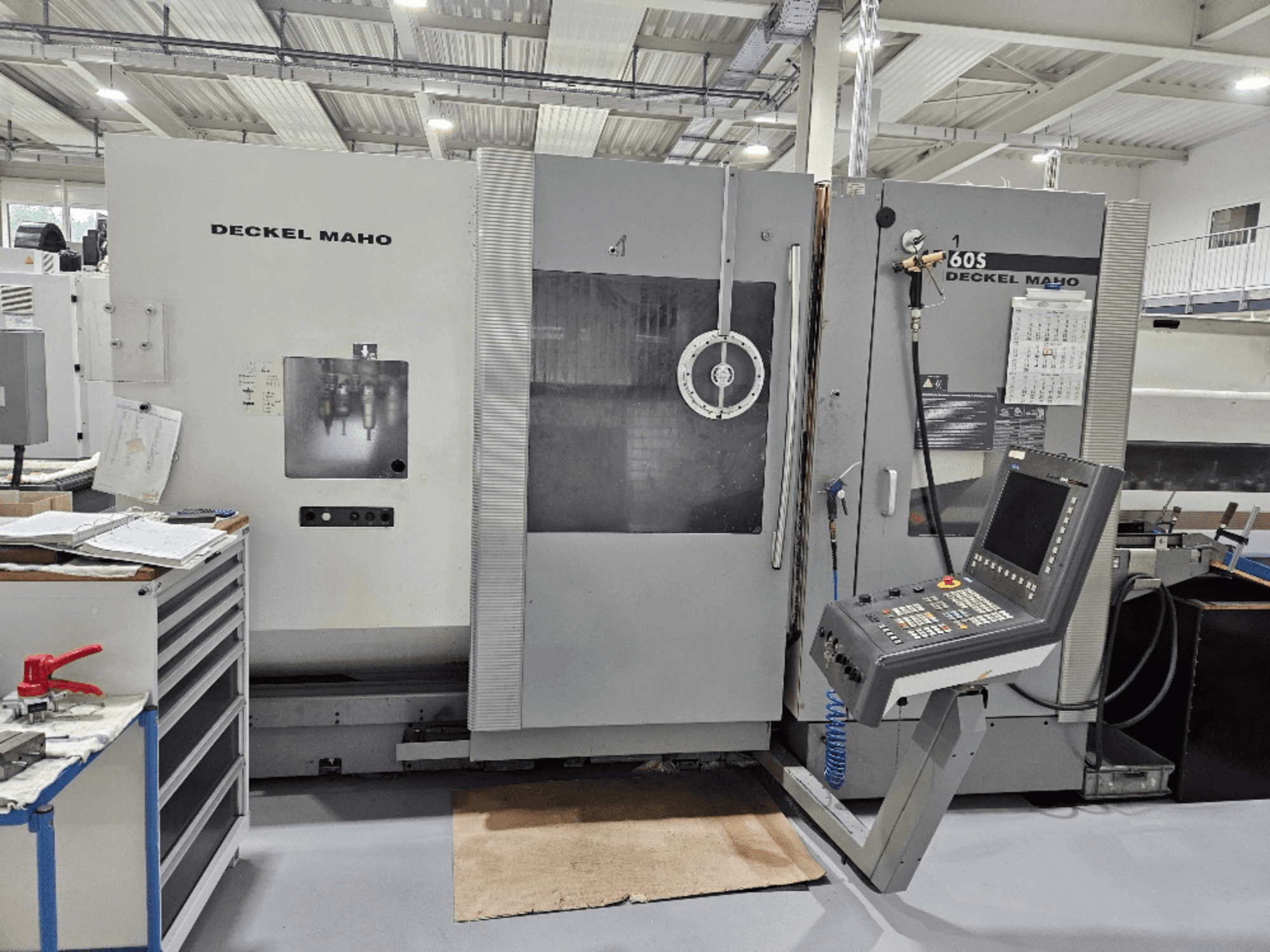 Deckel Maho 605 CNC-maskin med kontrollpanel och driftsfunktioner, sedd framifrån i en verkstadsmiljö.