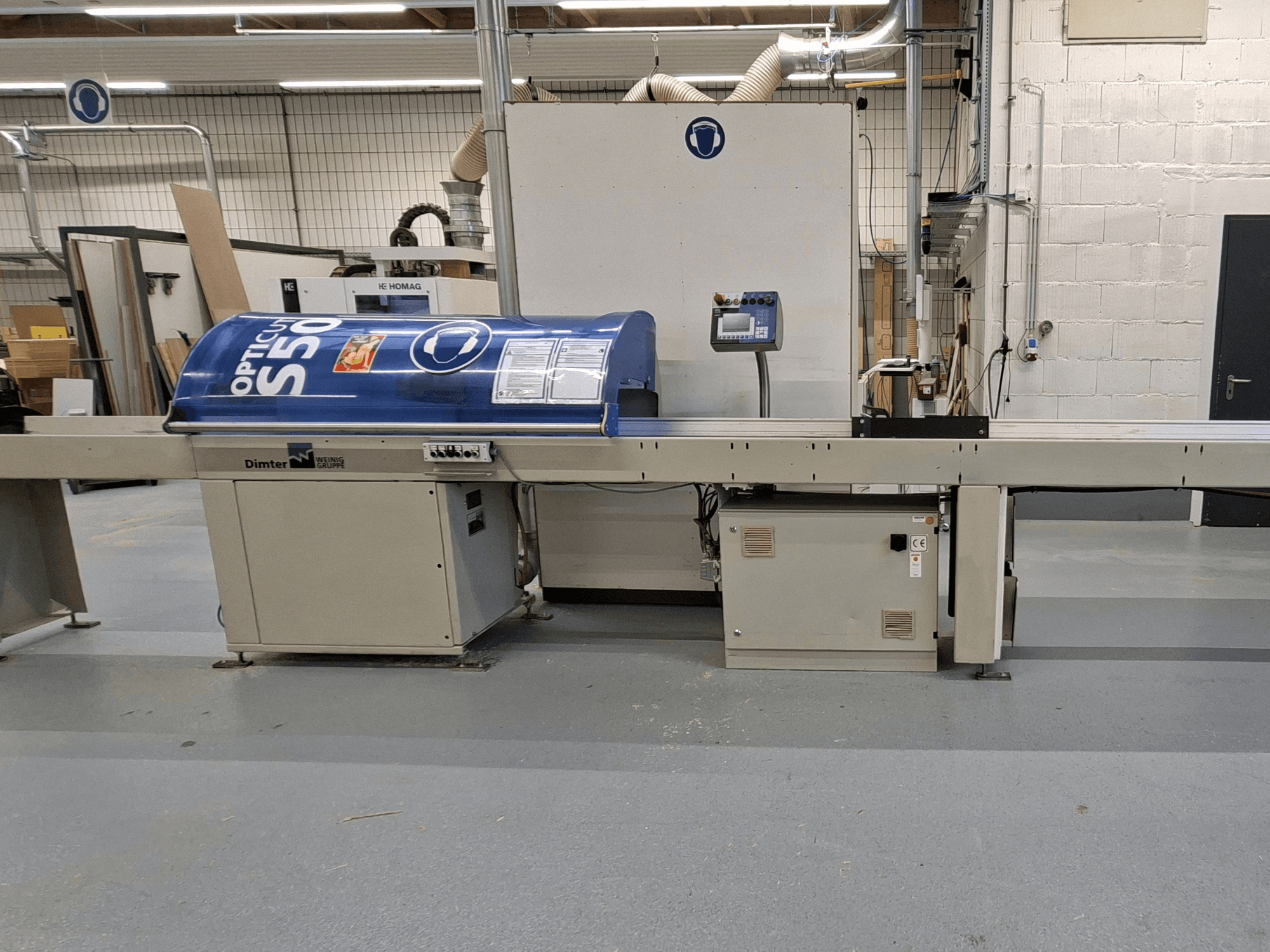 Dimter OptiCut S50 träkapmaskin i sidovy, med blått hölje, kontrollpanel och transportband.