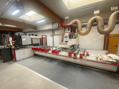 CNC-maskinen BIMA 400 sedd framifrån, med röd och vit design och dammutsugningssystem.