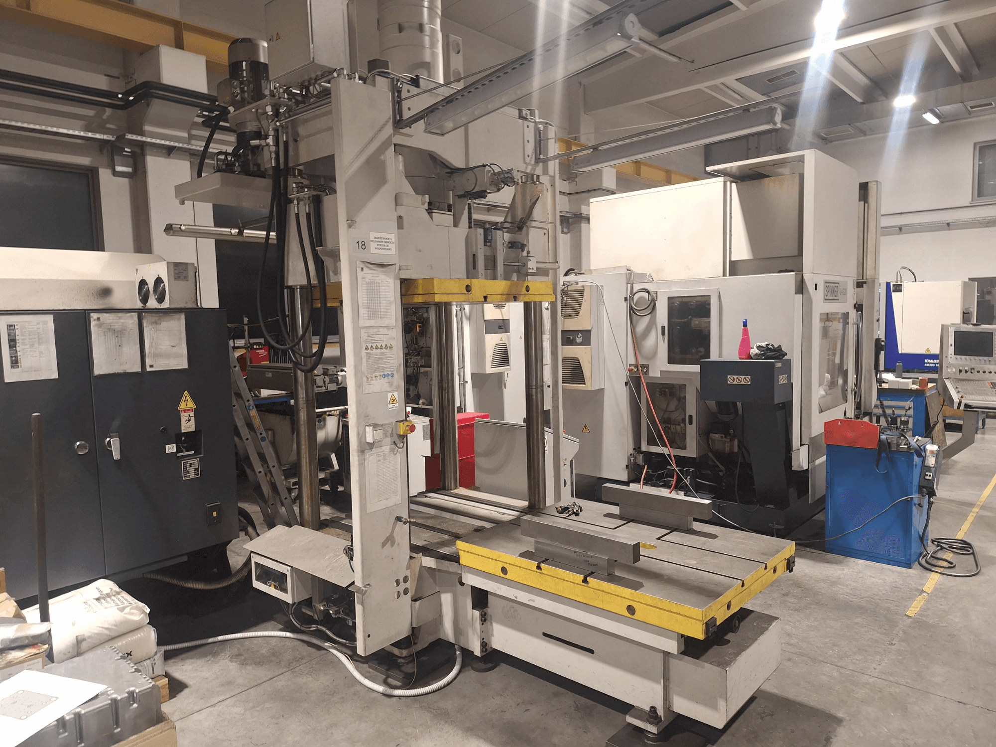 Horisontell fräsmaskin från Synergic, vy framifrån; har ett brett bord och olika kontrollpaneler, i en verkstadsmiljö.