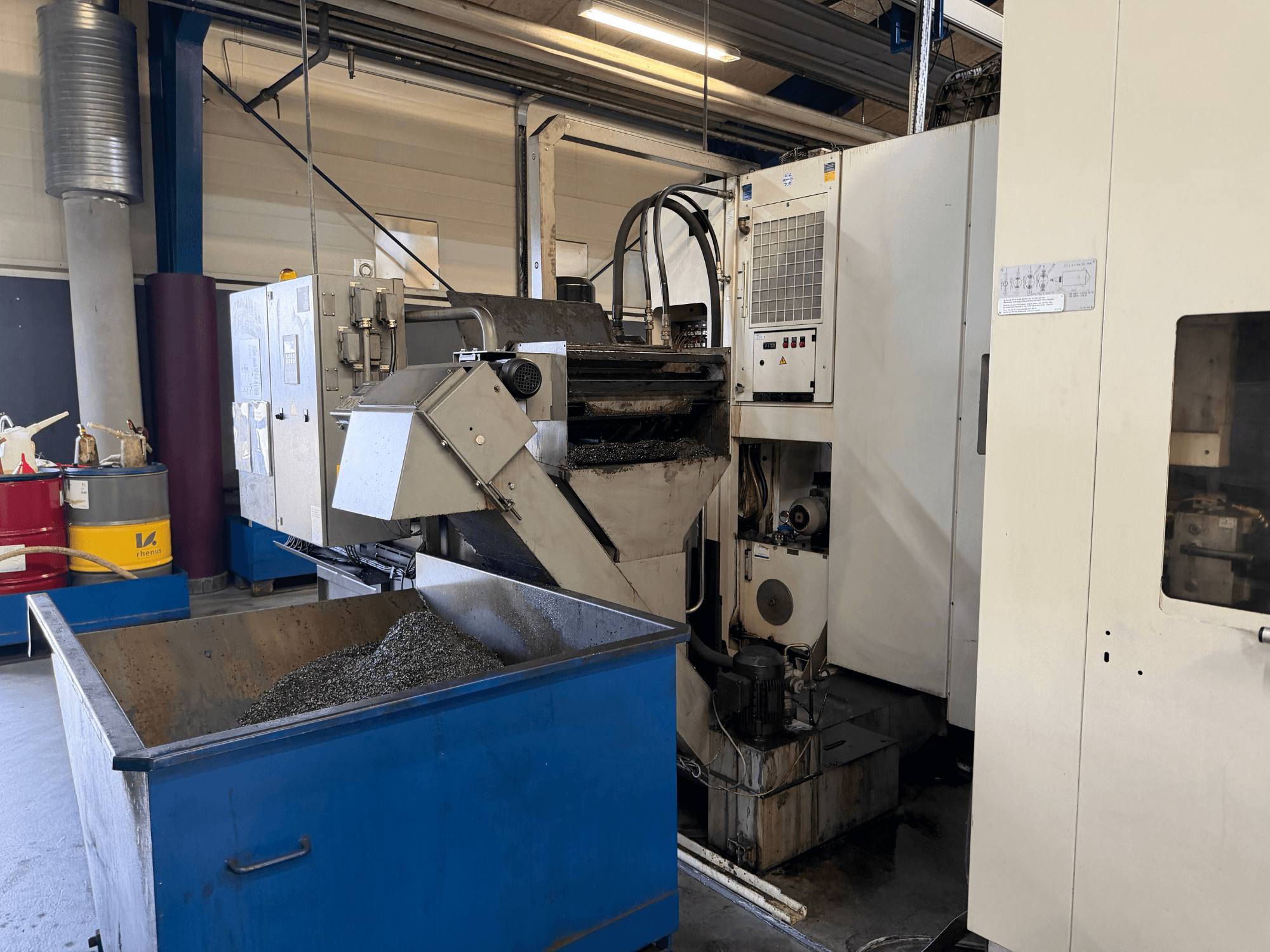 Frontvy av HELLER MCH 250 horisontell fleroperationsmaskin med återvinningsbehållare för kylvätska och kontrollpanel synlig.