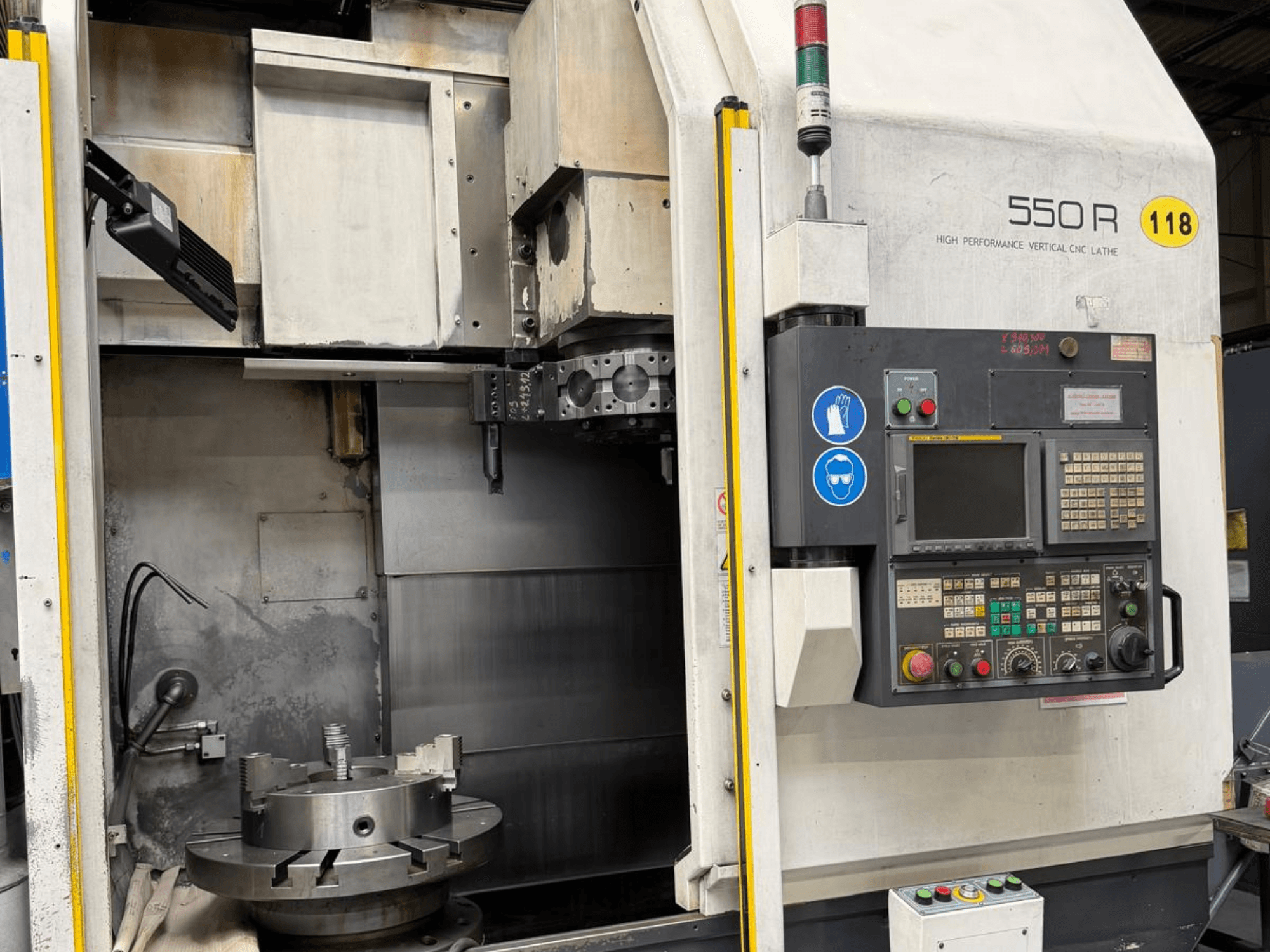 Högpresterande vertikal CNC-svarv 550 R, framifrån, med kontrollpanel, roterande chuck och operativa komponenter.