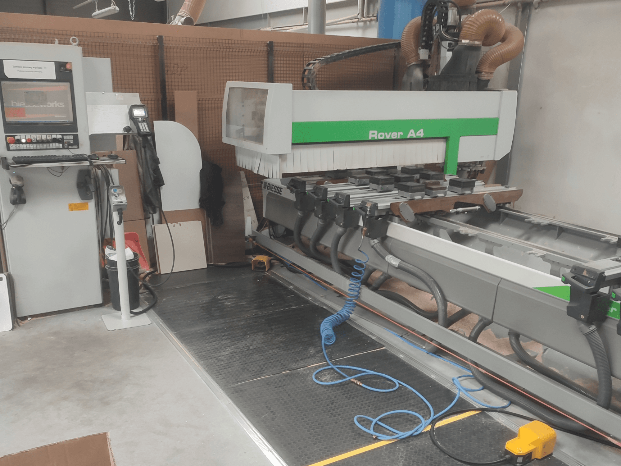 BIESSE Rover A4 CNC-bearbetningscenter för trä i sidovy, där man ser kontrollpanelen, vakuumfästena och dammutsugssystemet.