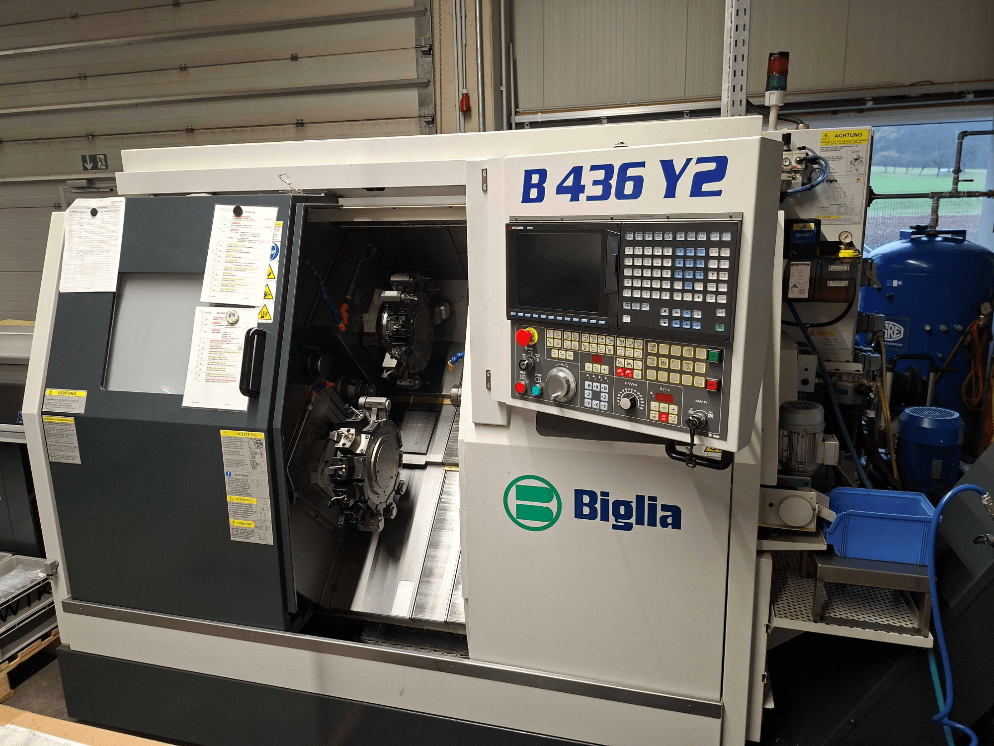 Biglia B 436 Y2 CNC-svarv i sidovy, med dubbla spindlar och kontrollpanel med knappar och display för operationer.