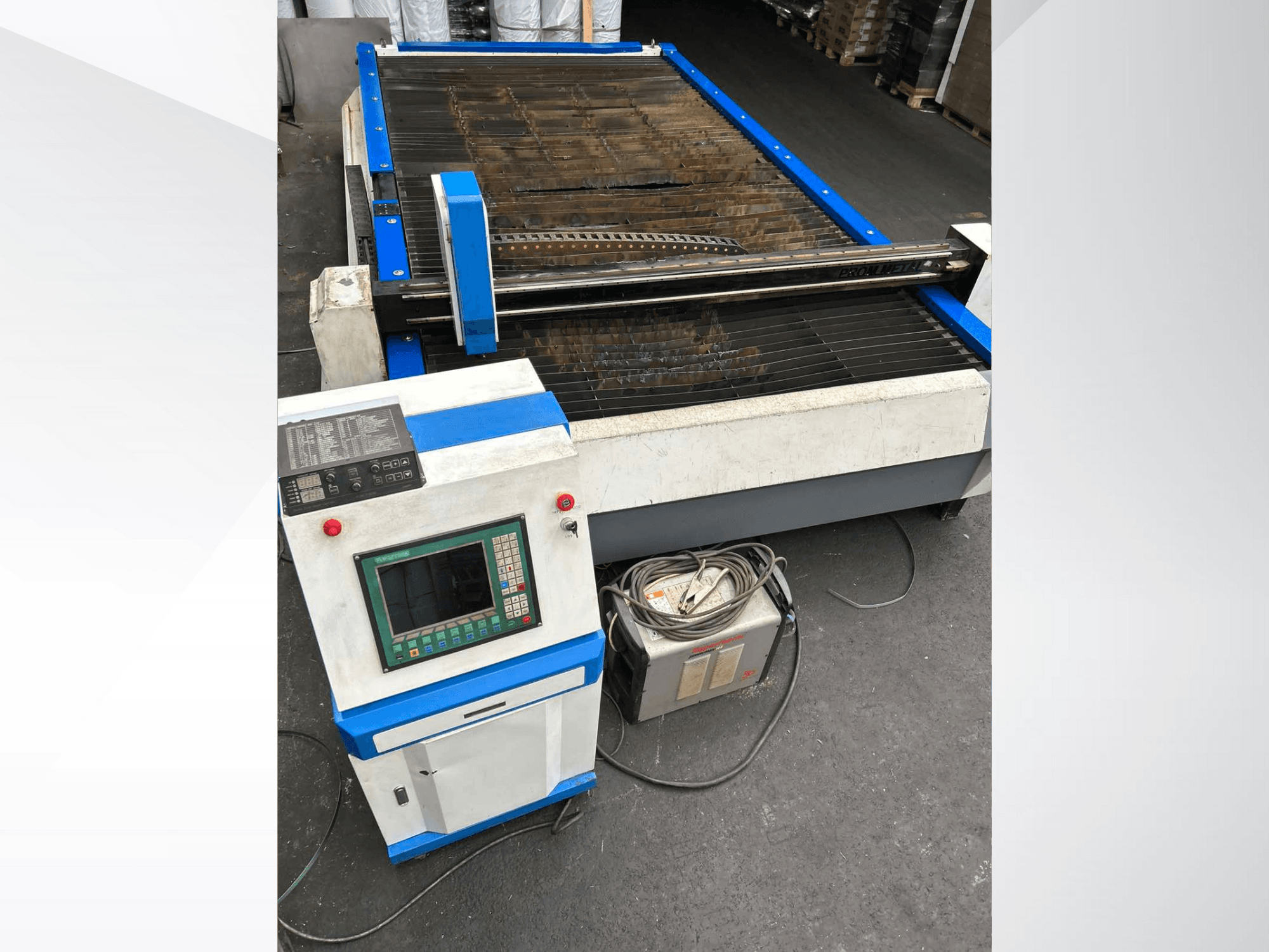 CNC-plasmaskärmaskin med kontrollpanel, framifrån, med blå accenter och kablar på golvet.