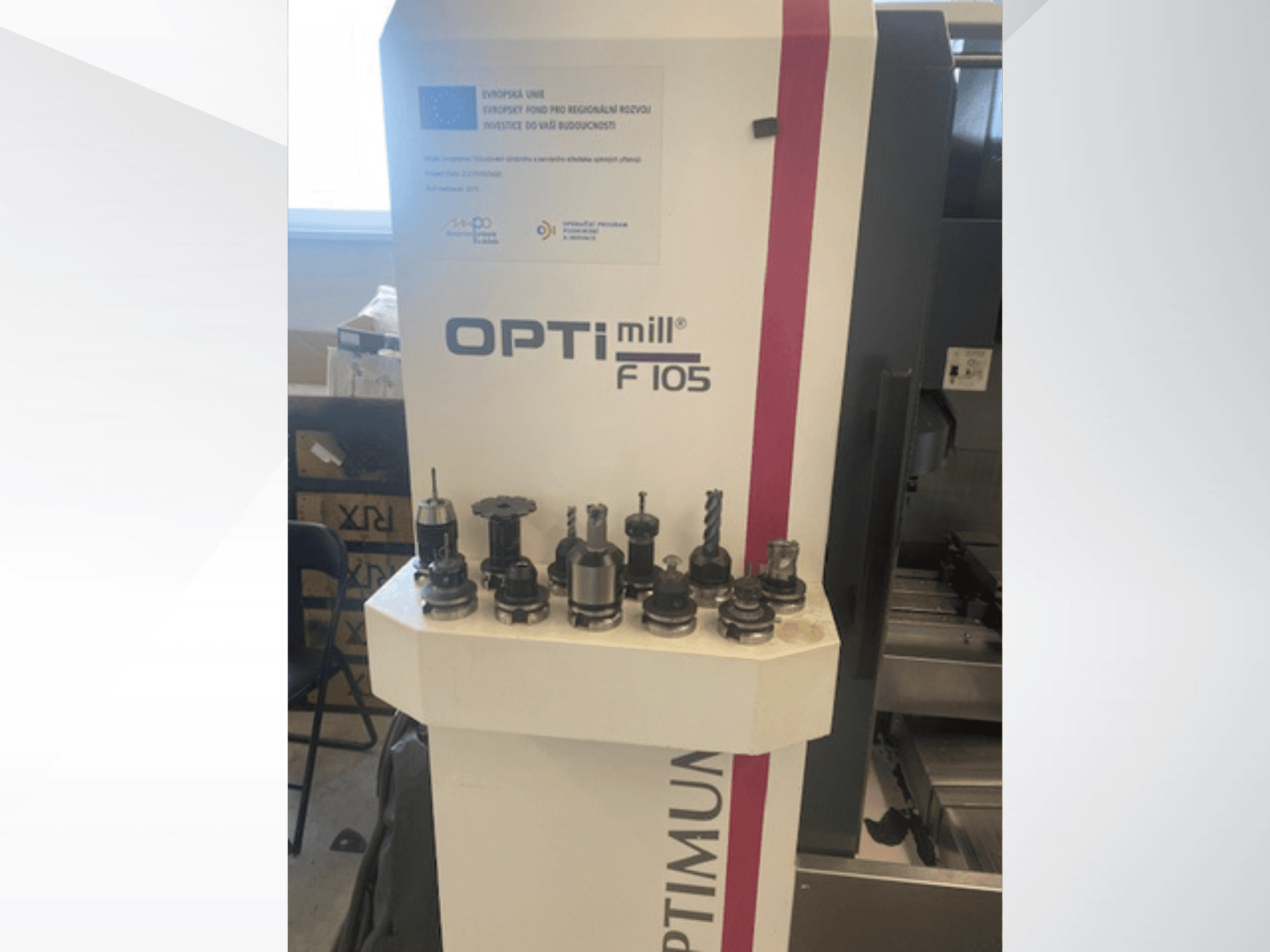 Framifrån sett på det vertikala bearbetningscentret Optimum Optimill F105 med olika monterade verktyg synliga på sidan.