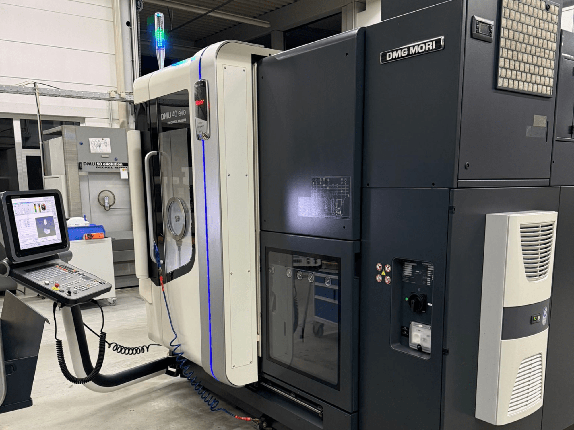 DMG MORI DMU 40 eVo-maskin, frontvy som visar reglage, LED-indikatorer och en elegant design som framhäver industriella egenskaper.
