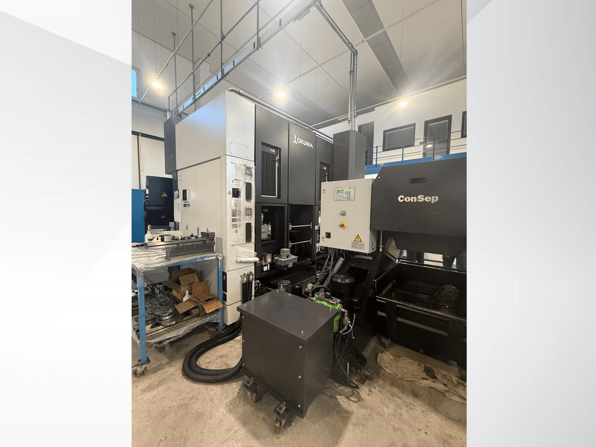 Okuma bearbetningscenter med ConSep-enhet, sidovy, visar reglage och industriell uppställning, inklusive behållare för metallspån.