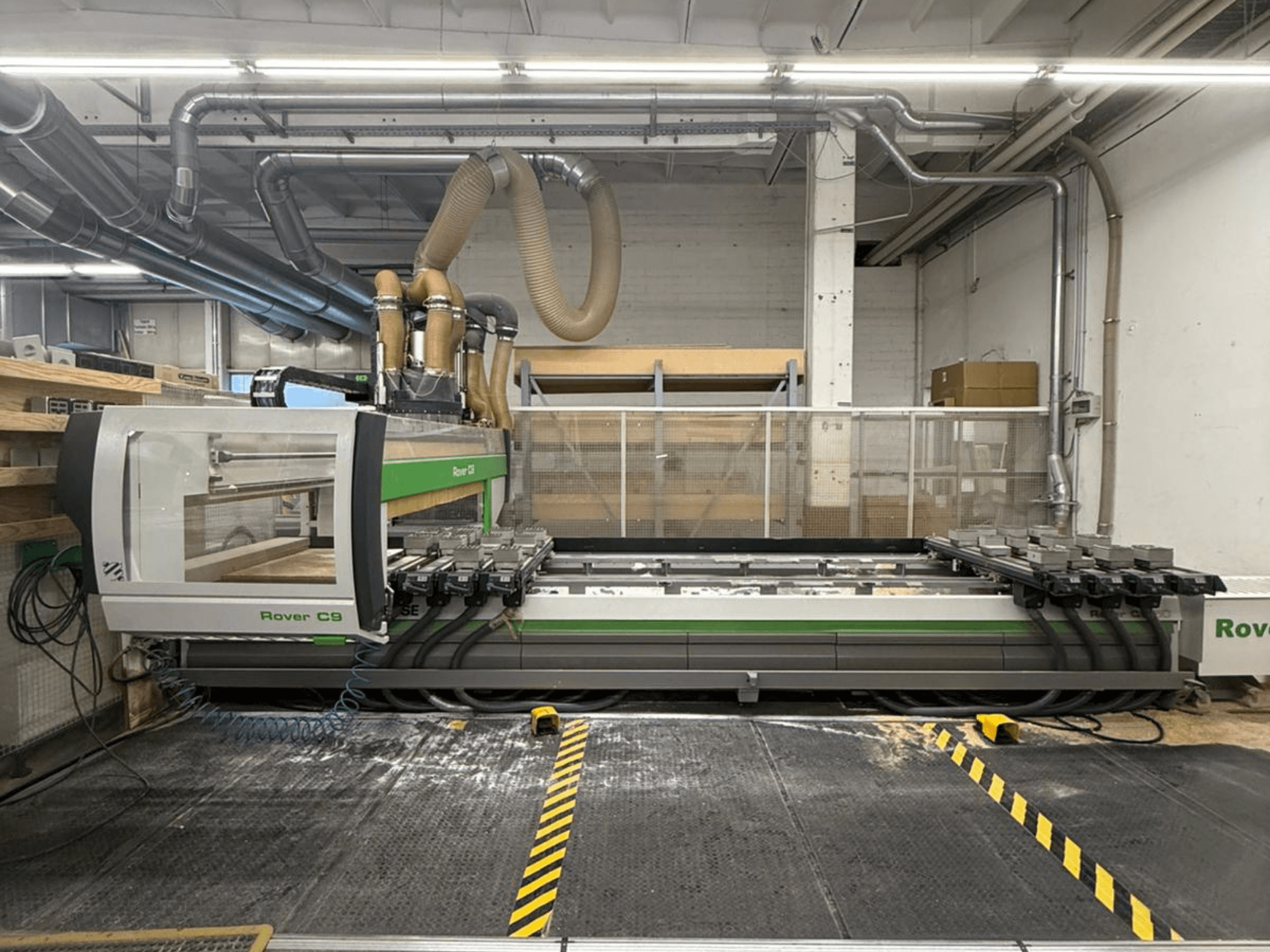 Rover C9 CNC-maskin i en verkstad, vy framifrån, med flera skärhuvuden och synligt dammutsugningssystem.
