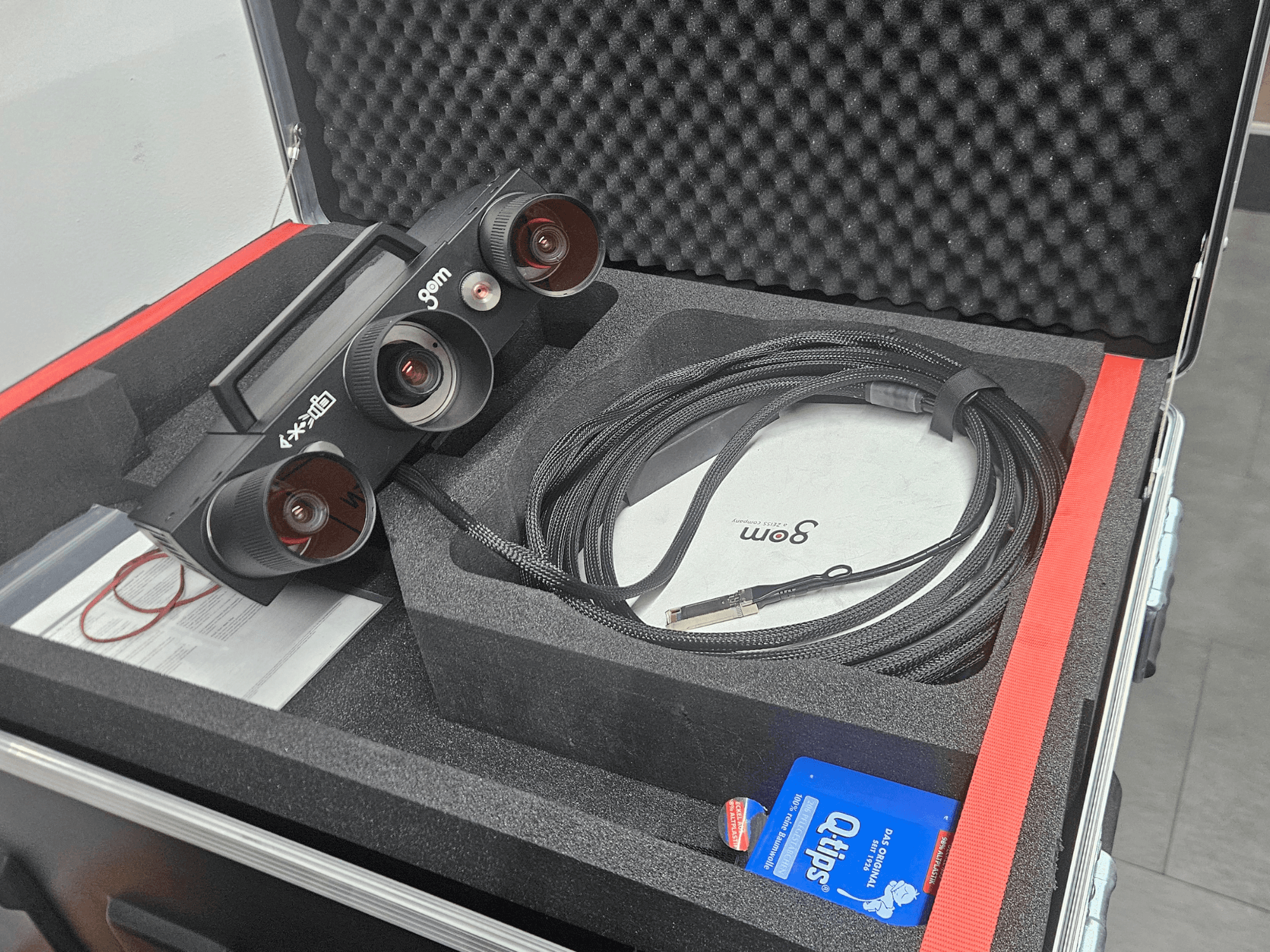 ZEISS GOM ATOS 5 optisk mätmaskin med linser och kabel, sedd uppifrån i skumplastfodral.