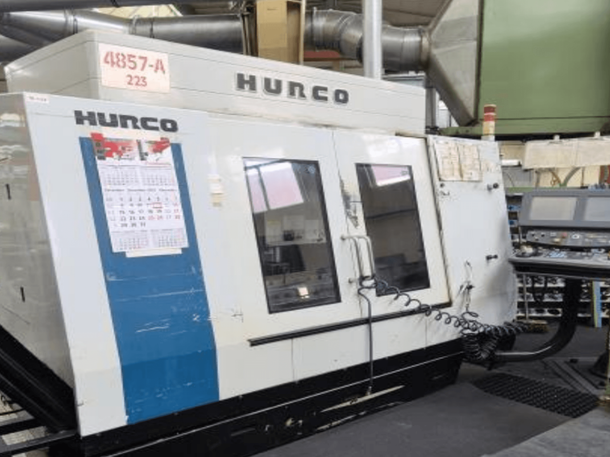 Hurco VMX 42 vertikal fleroperationsmaskin framifrån, med kontrollpanel, kalender och yttre metalldetaljer.
