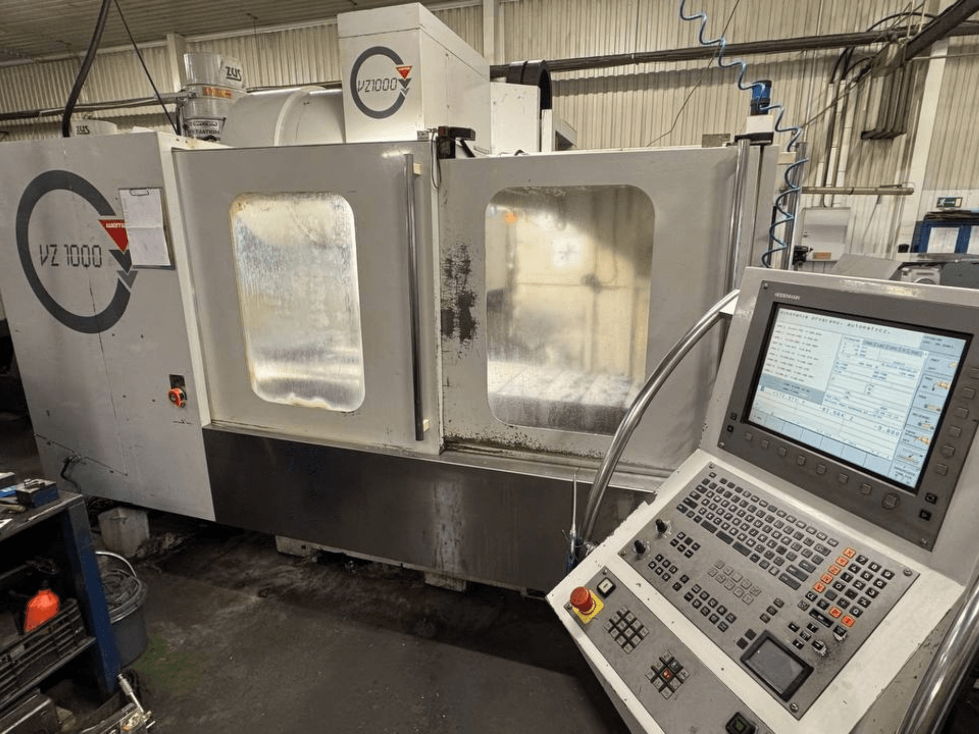 Frontvy av WEMAS VZ 1000 vertikala fleroperationsmaskin med kontrollpanel och genomskinliga dörrar.