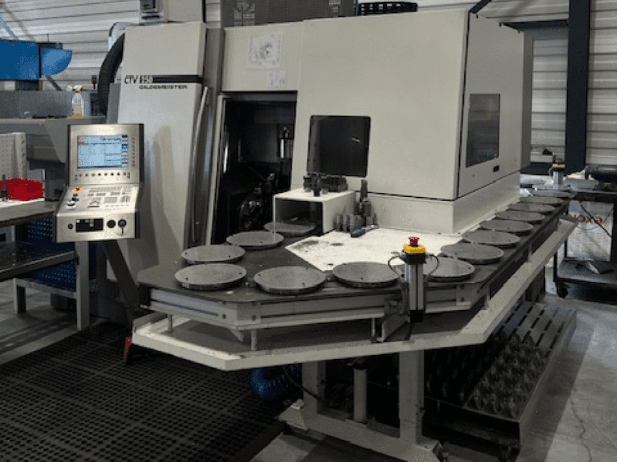 Alt text: CTV E33 Goldmeister-bearbetningsenhet i en verkstad, framifrån, med kontrollpanel och flera cirkulära arbetsplattformar.