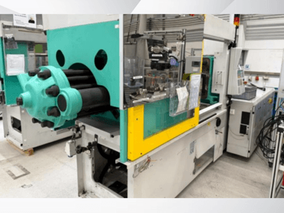 Formsprutningsmaskin, ljusblå och gul, framifrån, med synlig form och kontrollpanel med etiketter.