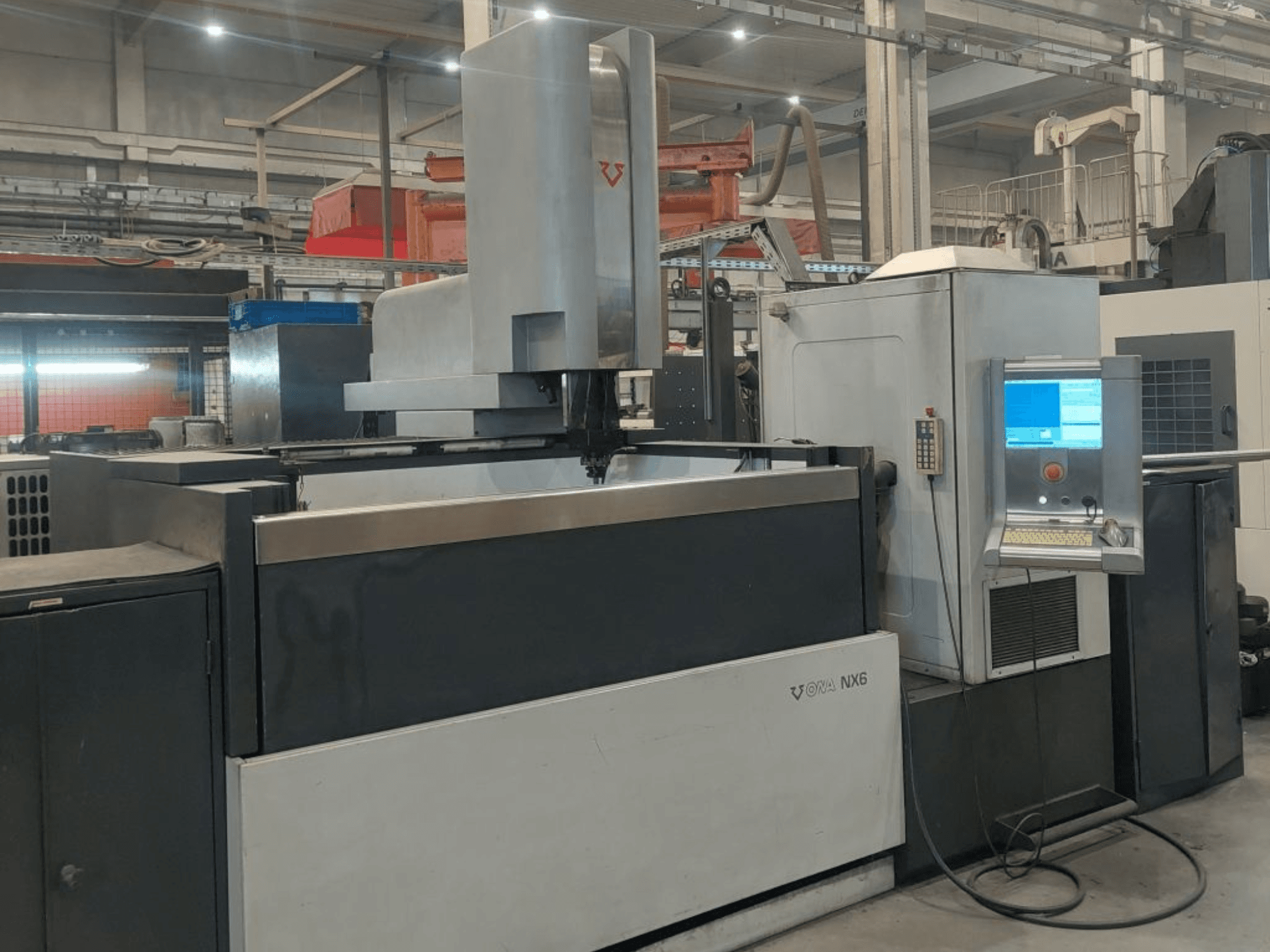 ONA NX6-sänkskärningsmaskin sedd framifrån, med en kontrollpanel och ett stort arbetsområde för precisionsbearbetning.