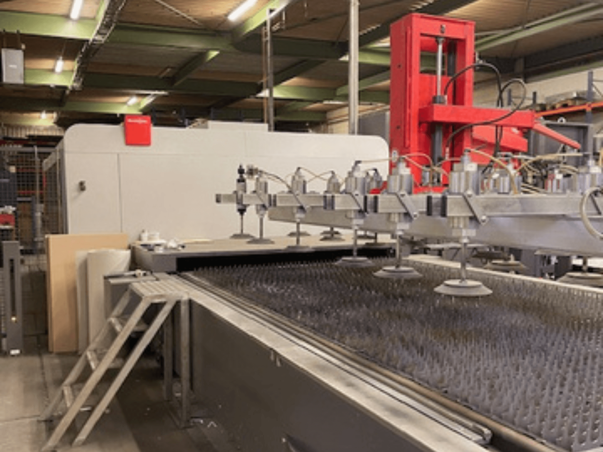 Bystronic BySprint Fiber 4020 Fiber 4Kw Frontvy av en fiberlaserskärmaskin med munstycken och skärbädd.