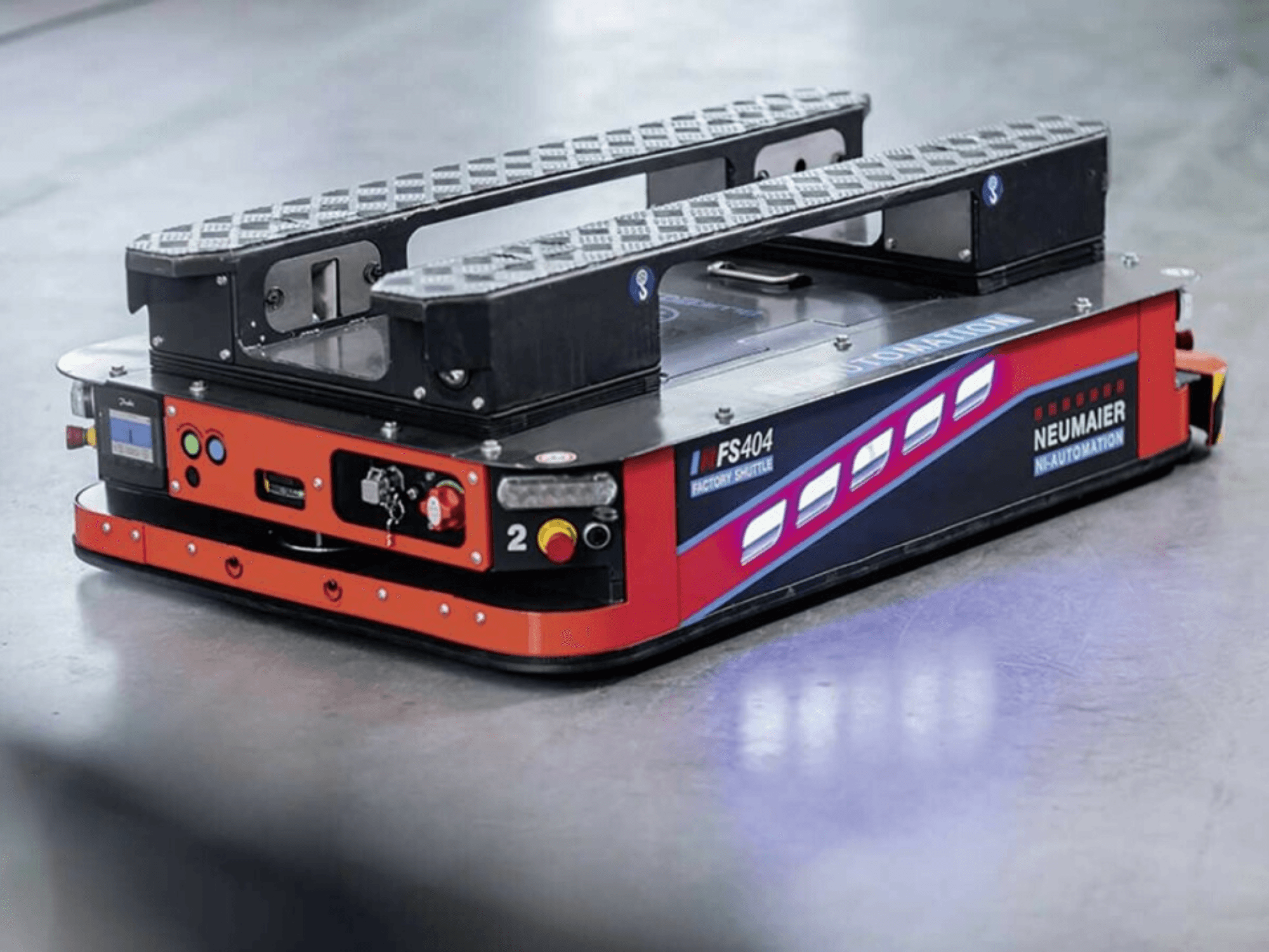 NEUMAIER AGV Factory Shuttle FS404, lågprofilerat pallhanteringssystem, sidovy som visar hjul, reglage och säkerhetsfunktioner.