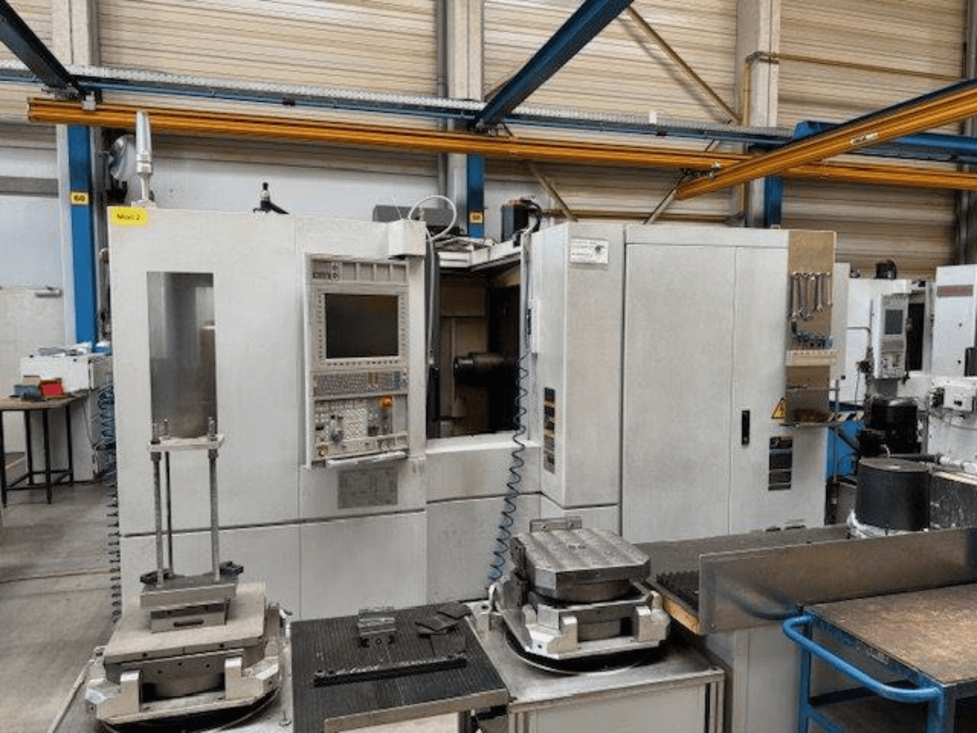 MORI SEIKI NH4000 DCG frontvy av en horisontell fleroperationsmaskin med kontrollpanel och arbetsstycken på bordet.