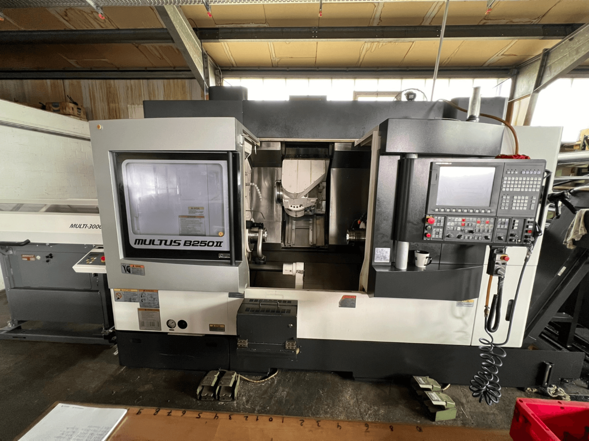 Okuma Multus B250II MW svarv- och fräscenter, framifrån, med detaljerad bild av kontrollpanelen och bearbetningsområdet.