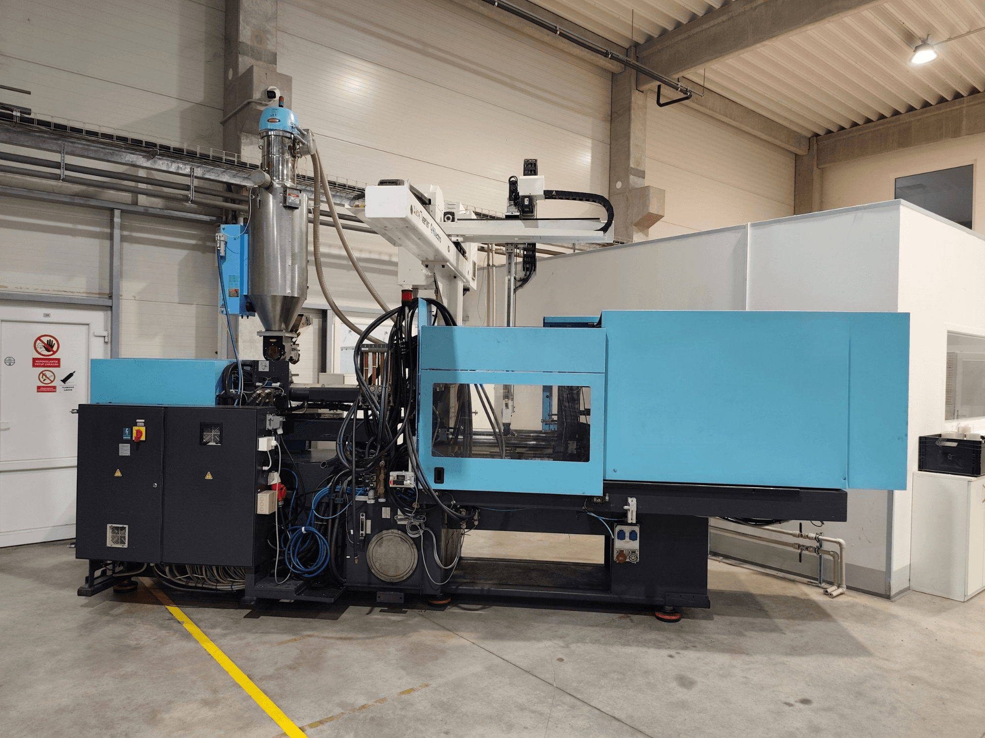 Framifrån sett på en hydraulisk formsprutningsmaskin av typen DEMAG Ergotech Extra 160-430, med synlig kontrollpanel och matartank.