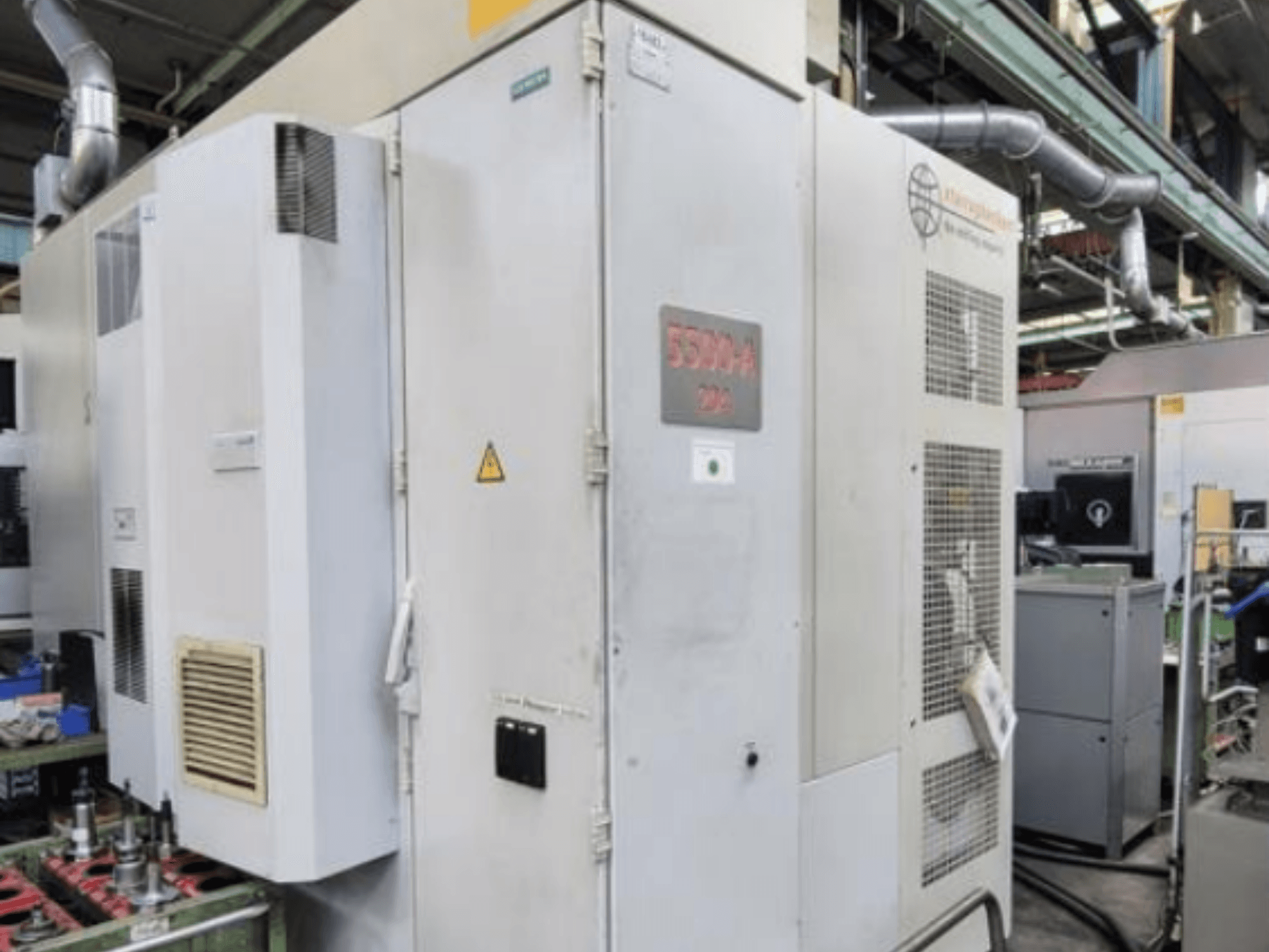 Starrag Heckert HEC 500 H/V horisontell fleroperationsmaskin, sidovy som visar utsidan med ventilationsöppningar och varningsskyltar.