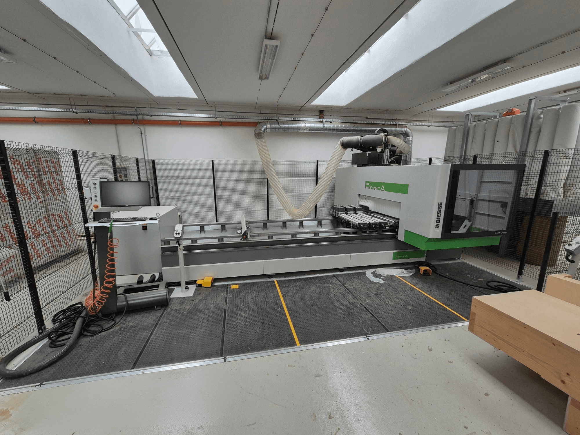 Biesse Rover En CNC-maskin i en verkstad, framifrån. Med kontrollpanel, vakuumsystem och arbetsyta.