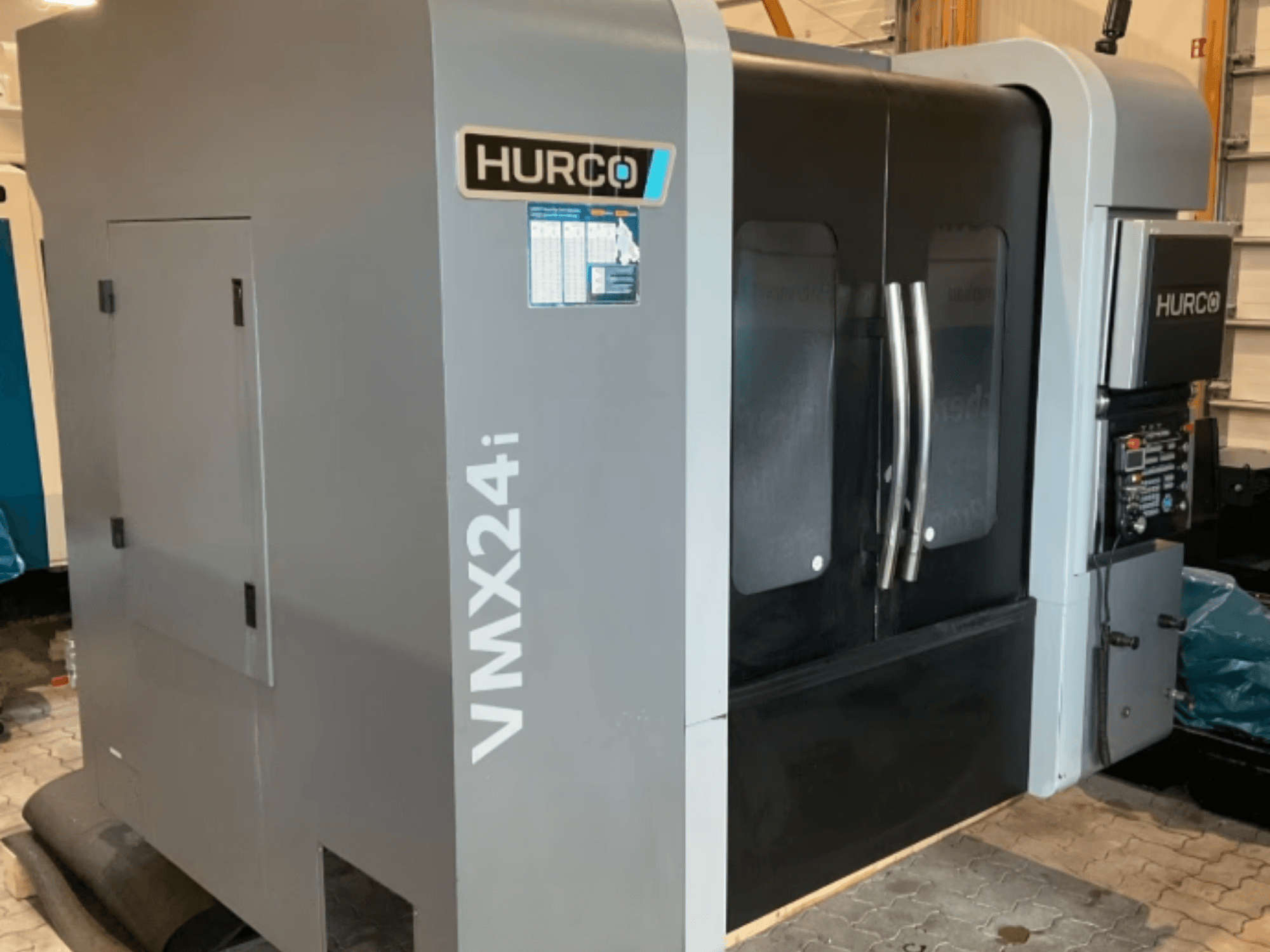 Hurco VMX 24i vertikalt bearbetningscenter, framifrån sett med metallgrå kaross, svarta luckor och manöverpanel.