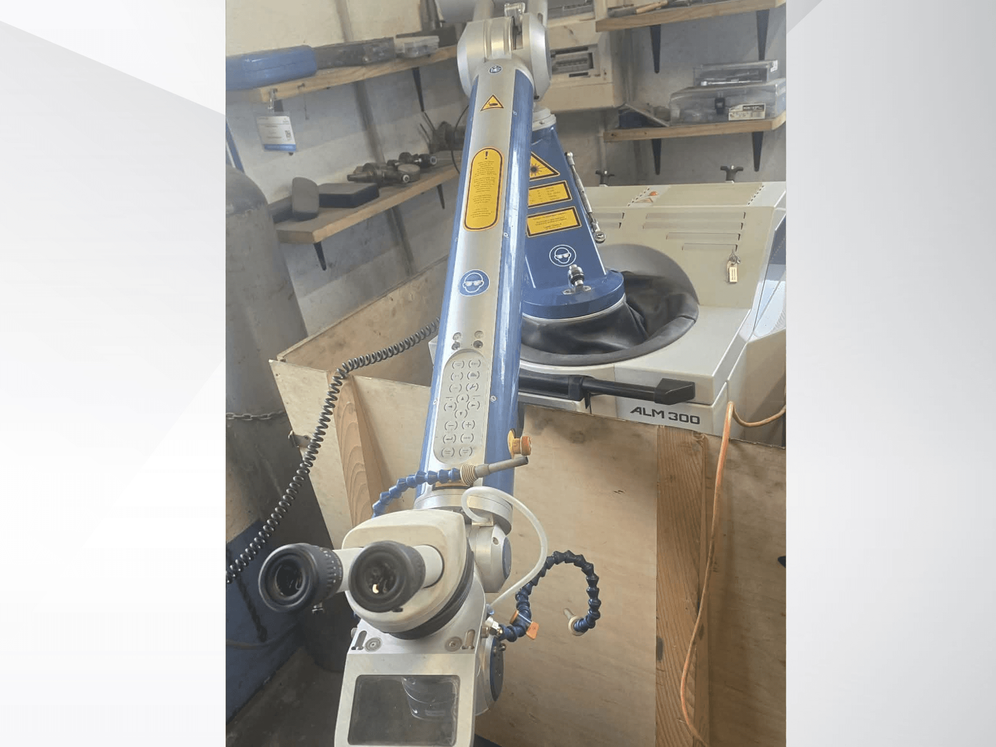 Framifrån sett av lasersvetsmaskinen ALPHA LASER ALM 300, utrustad med en robotarm, optiska linser och en kontrollpanel.