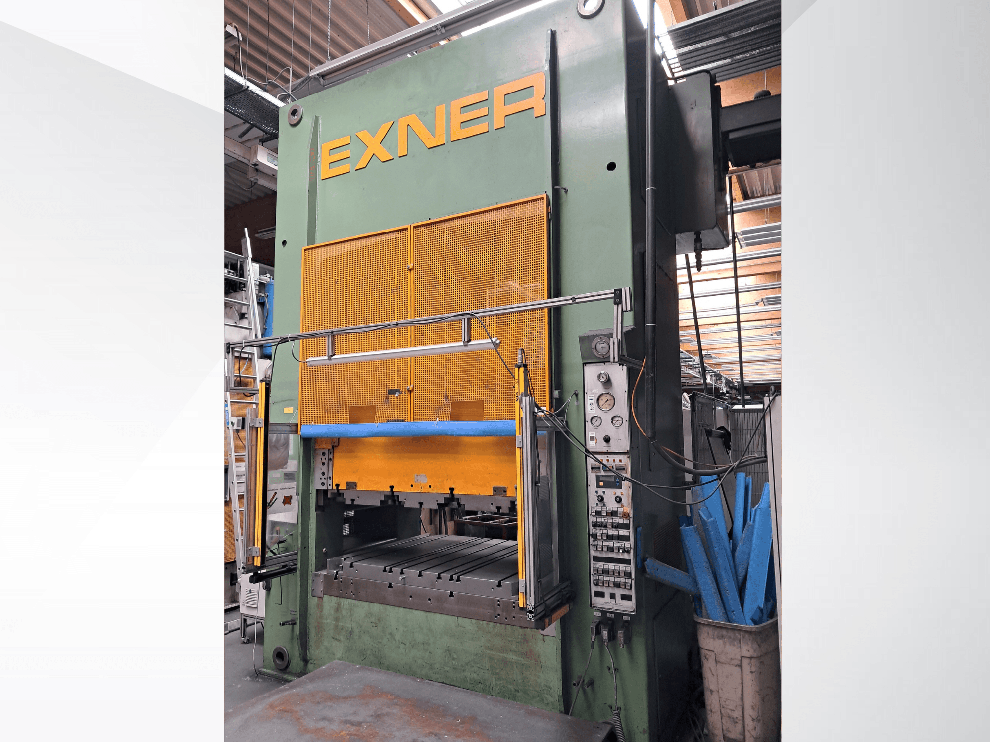 Hydraulpress EXNER EX SBR 150, framifrån; med manöverpanel, blå säkerhetsstång och nätskydd, placerad i en verkstadsmiljö.