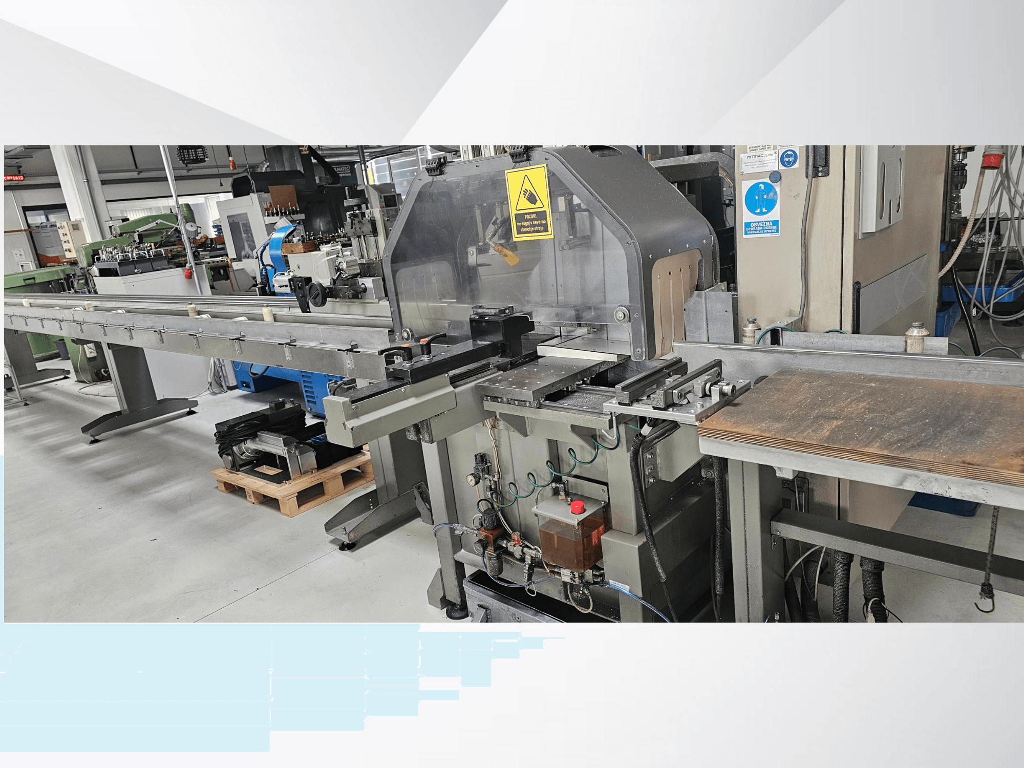 Industriell skärmaskin från sidan, med en lång transportör, kontrollpanel och säkerhetsvarningar.