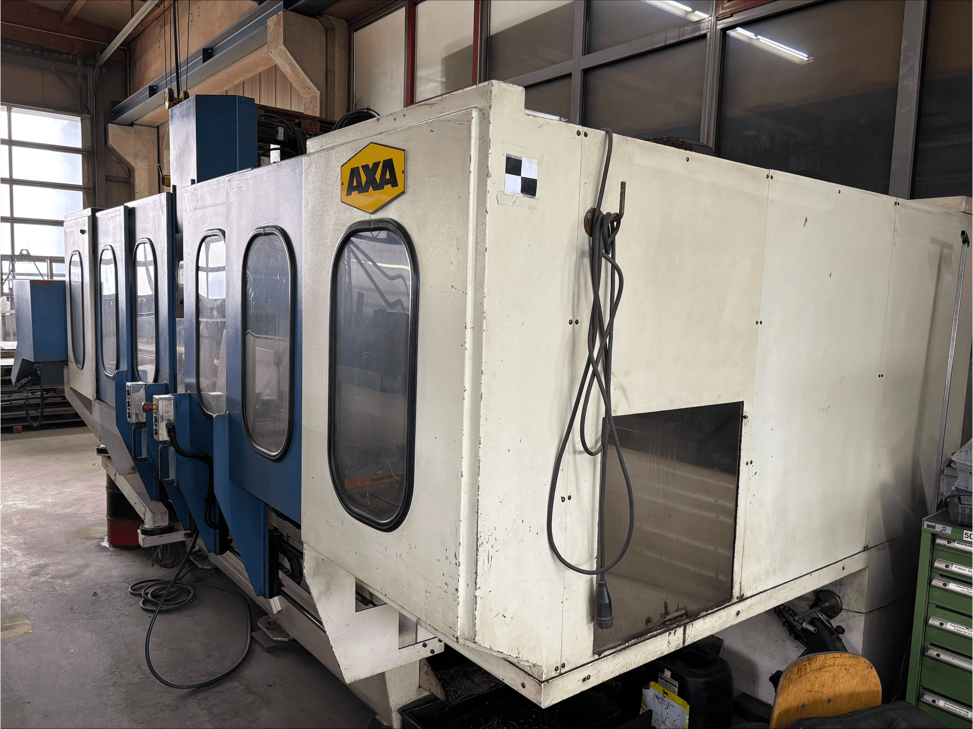 AXA VSC-1-M/C vertikal fleroperationsmaskin, framifrån, med ett stort vitt skåp och blå kontrollpanel.