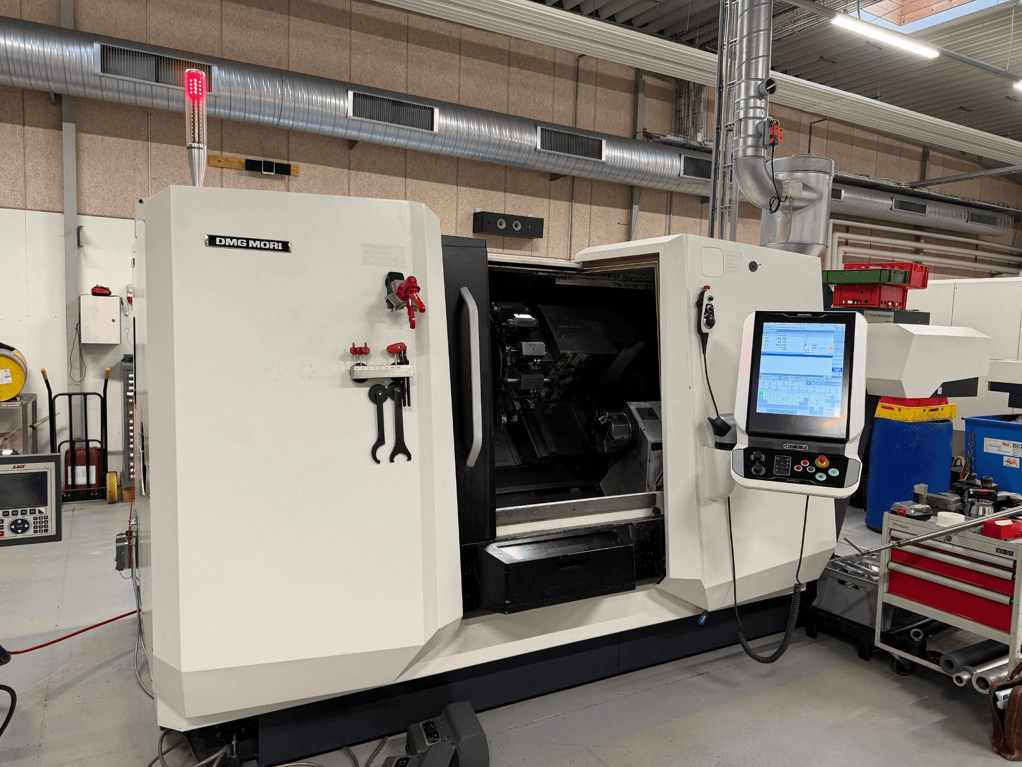 DMG MORI CLX 450 V6 horisontell svarv, framifrån sett med kontrollpanel, nödstopp och säkerhetslampa synliga.