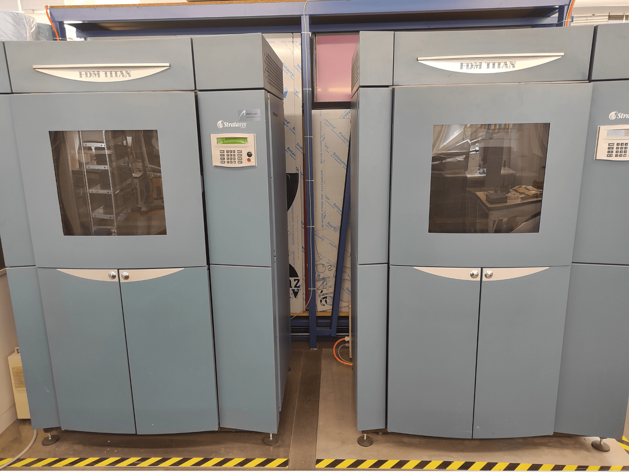 Framifrån sett på Stratasys FDM TitanTI T0031 3D-skrivare för plast; med displaypanel och genomskinligt fönster.