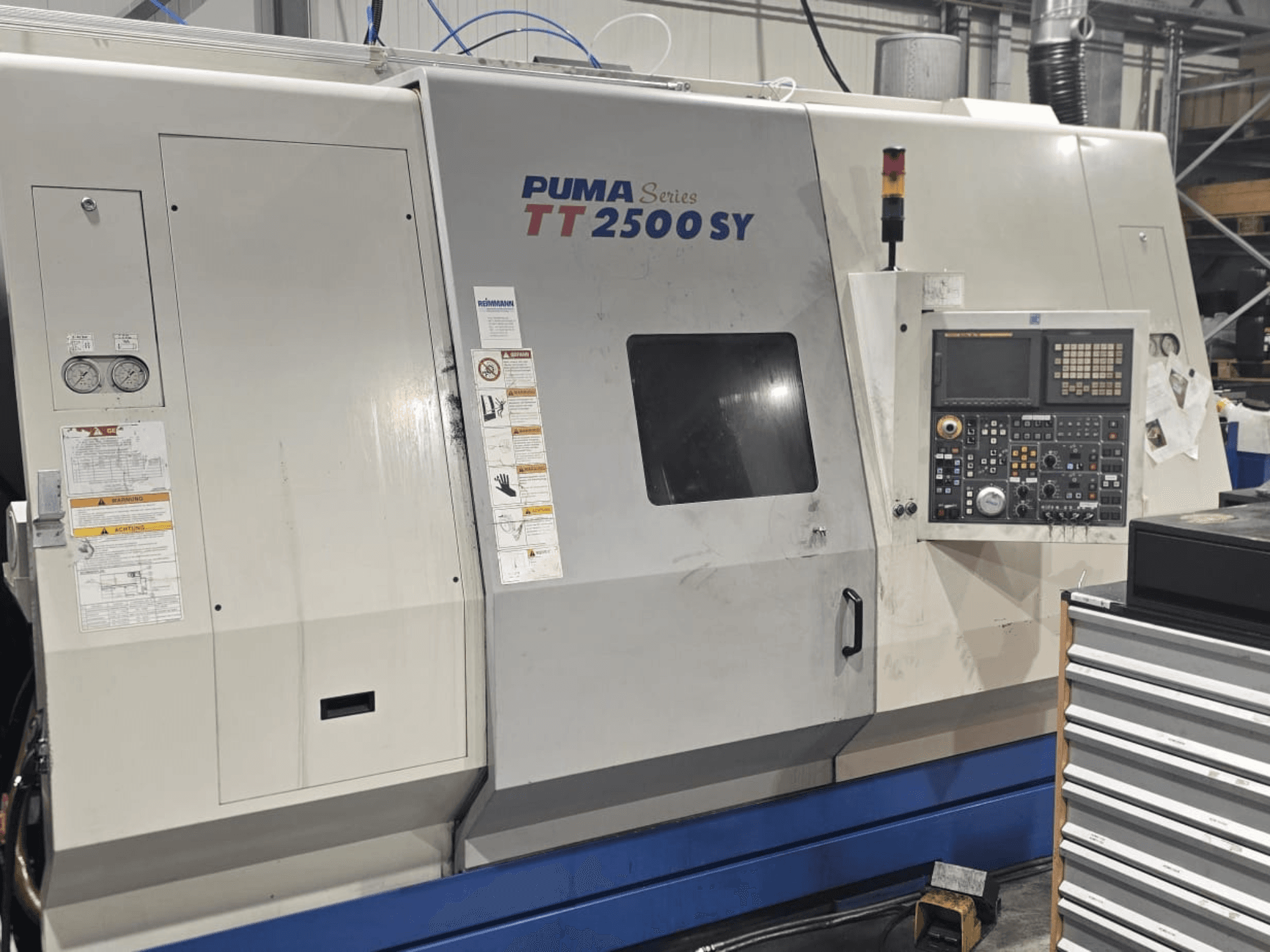 PUMA CNC-svarv serie TT 2500 SY, framifrån; kontrollpanelen med rattar och knappar, mätare och manöveretiketter är synliga.