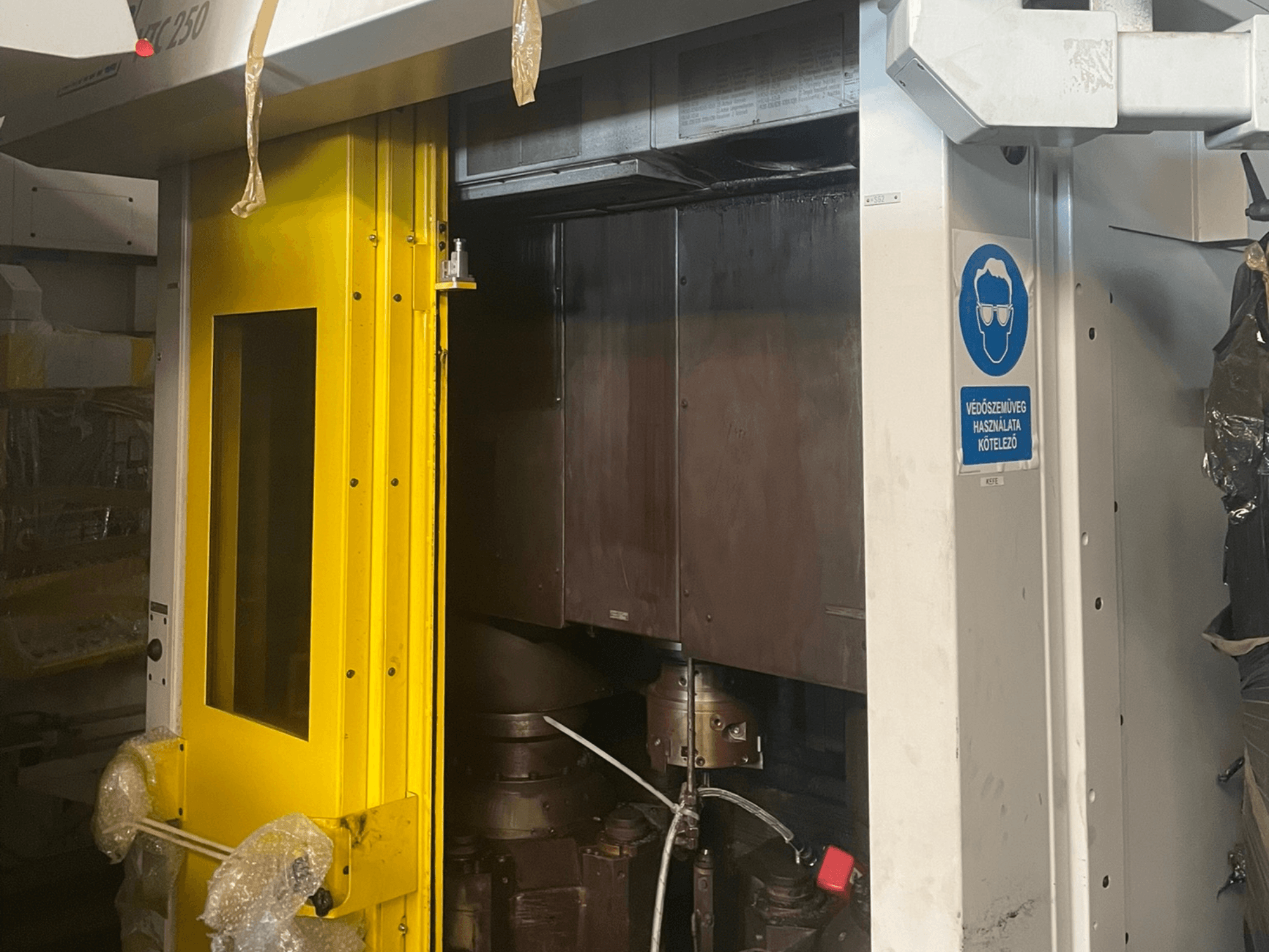 Gul entrédörr till en maskin med säkerhetsskylt, framifrån på en industrimaskin modell Z250, visar inre komponenter.