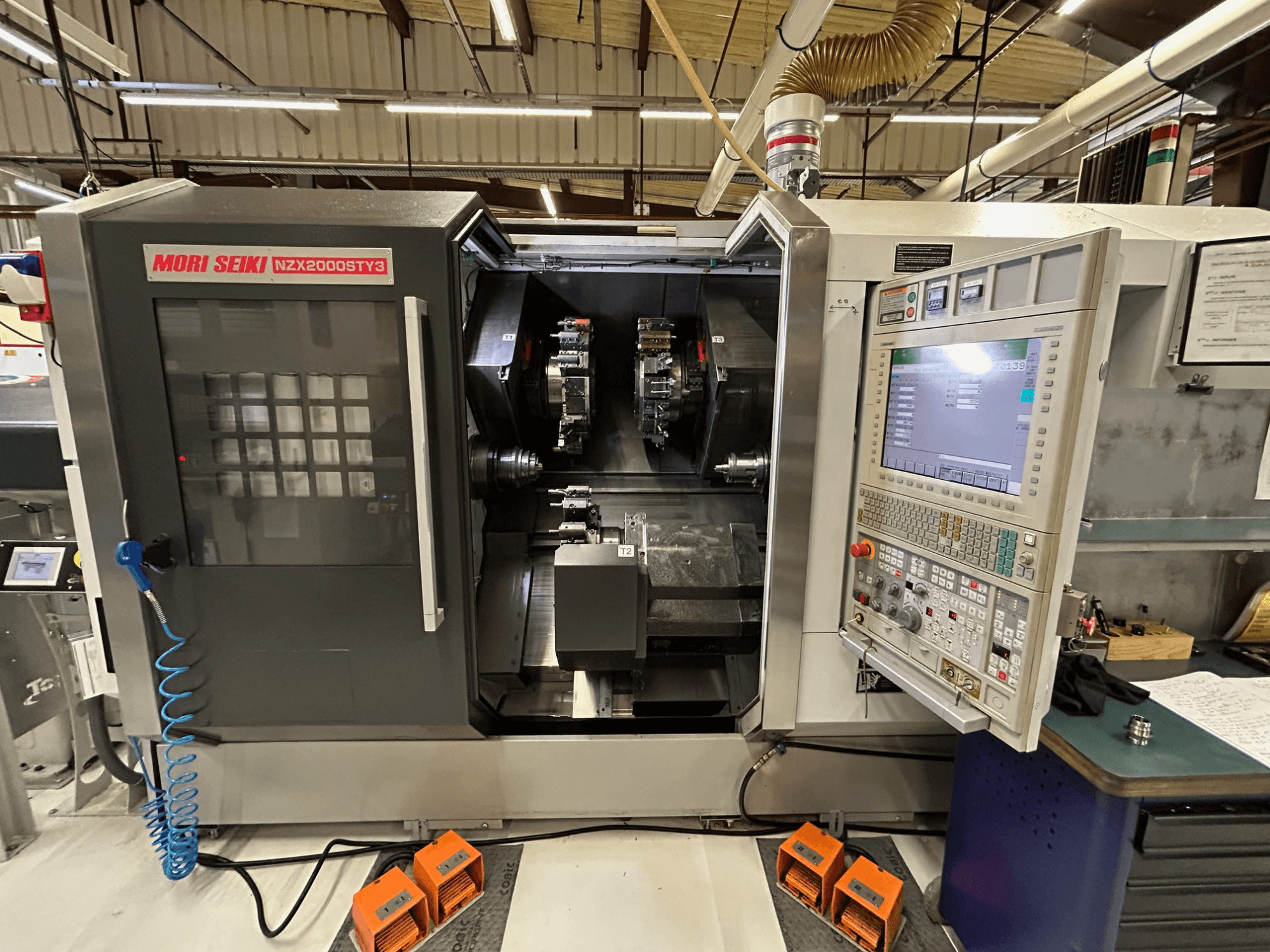 MORI SEIKI NZ2000 ST3Y3 flerspindlig svarv, framifrån med kontrollpanelen och bearbetningsområdet i förgrunden.