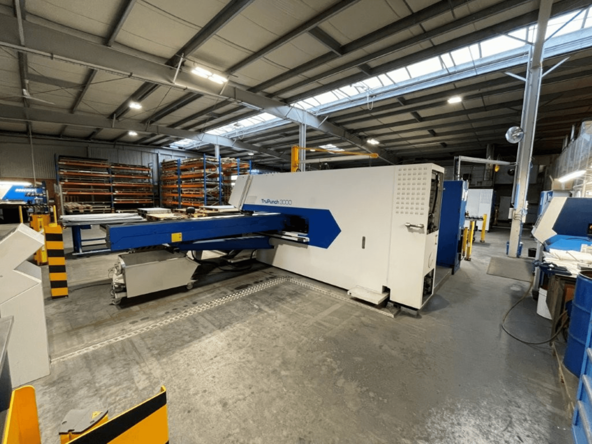 CNC-stansmaskinen TRUMPF TruPunch 3000 i en fabriksmiljö; framifrån syns dess blå och vita design samt de operativa komponenterna.