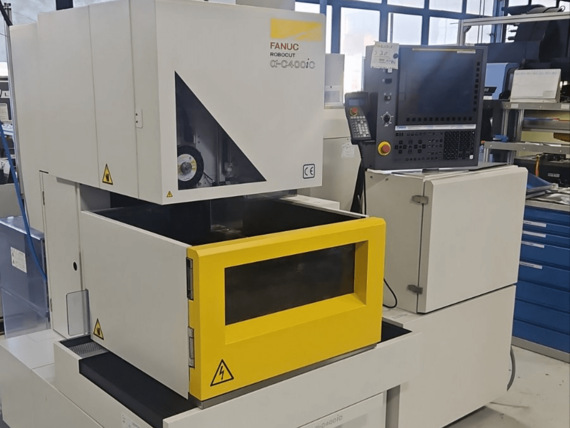FANUC Robocut alpha-C400iC, en sänkgnistmaskin, sedd framifrån, med en gul arbetsrumskammare och kontrollpanel.