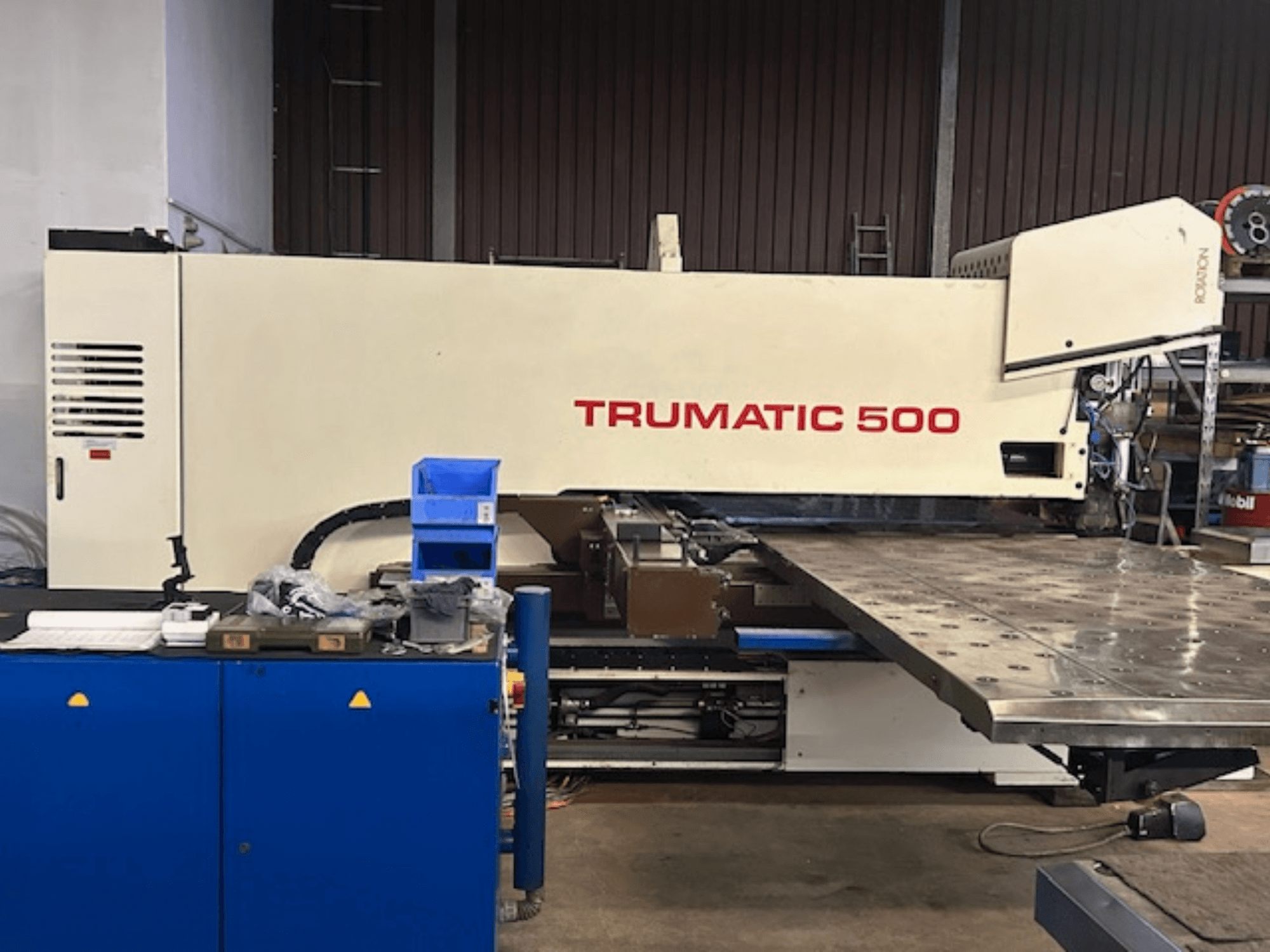 TRUMPF TRUMATIC 500 CNC-stansmaskin, framifrån, med kontrollpanel och ett stort arbetsbord med perforerad yta.