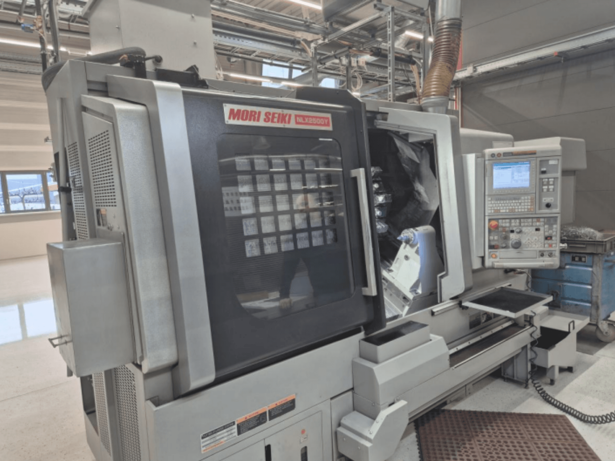 MORI SEIKI NL2500Y CNC-svarv i fabriksmiljö, framifrån med kontrollpanel och arbetsstyckeskammare.