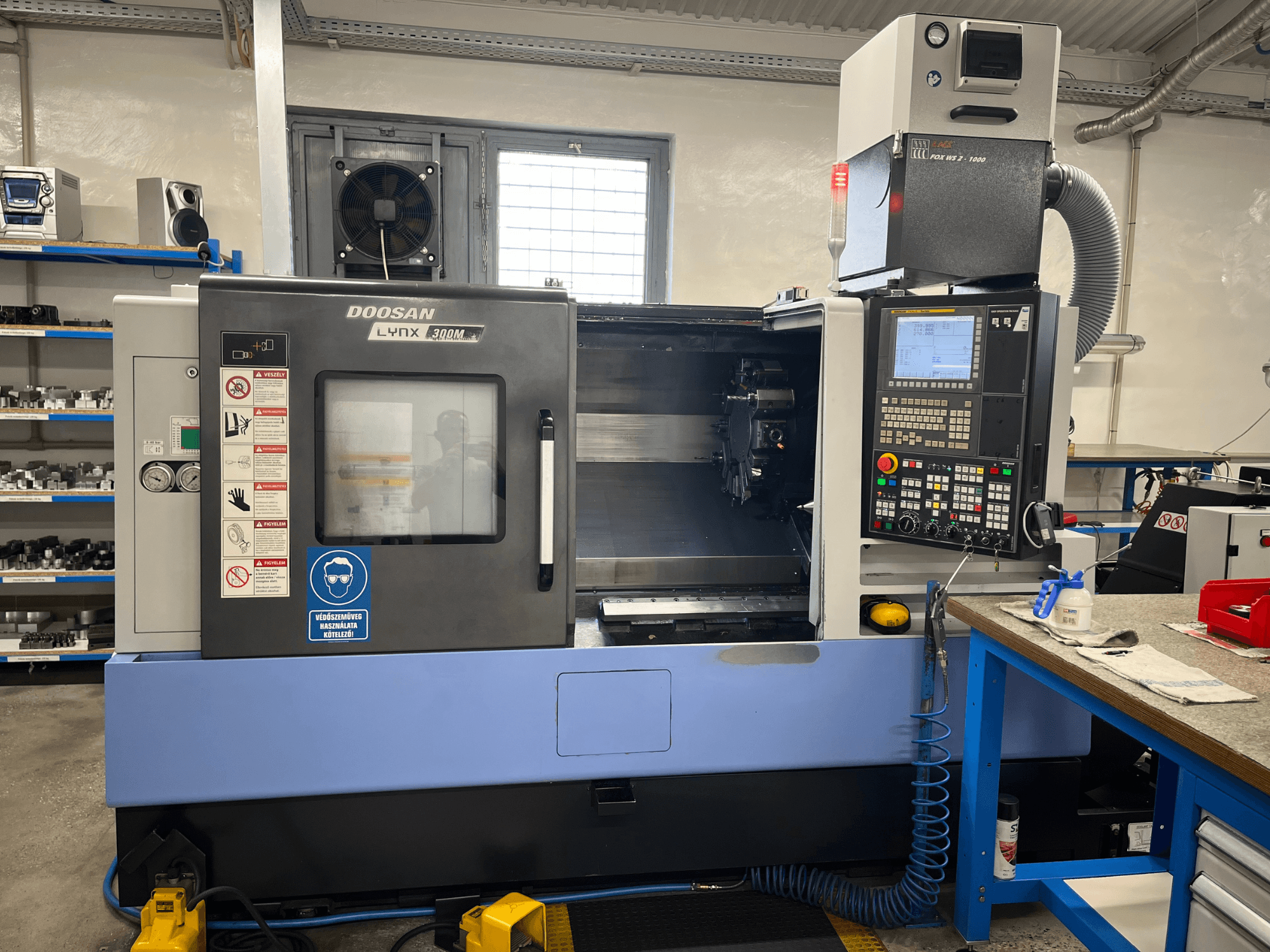DOOSAN LYNX 300M horisontell svarv, framifrån, med kontrollpanel och driftskomponenter.